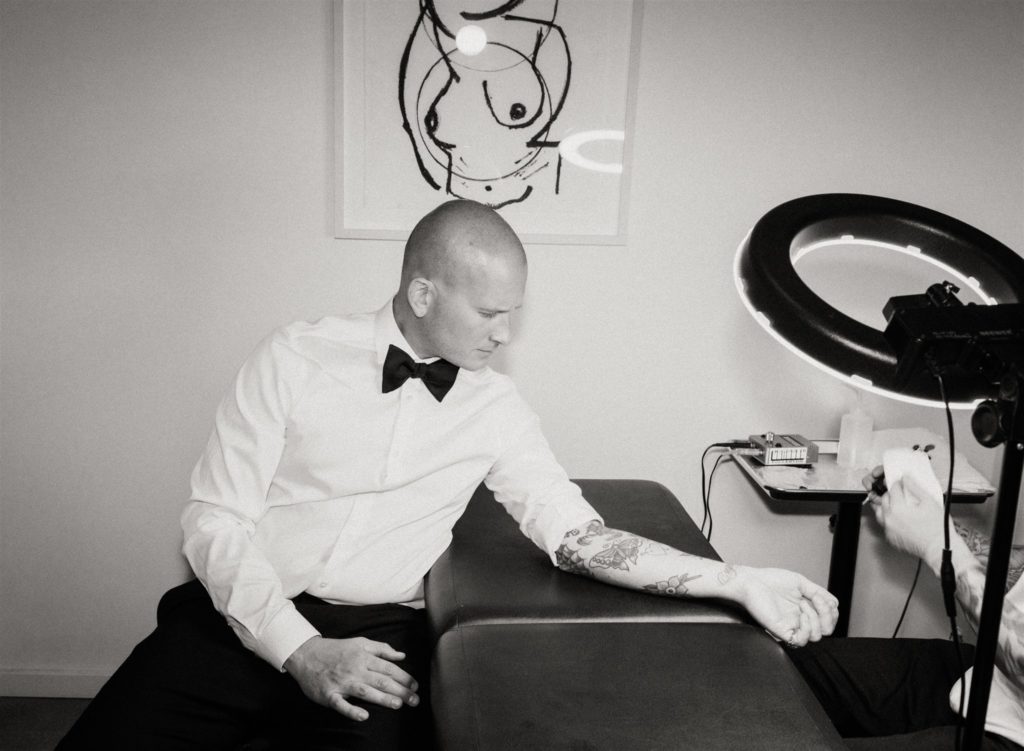 groom getting tattoo during wedding reception 