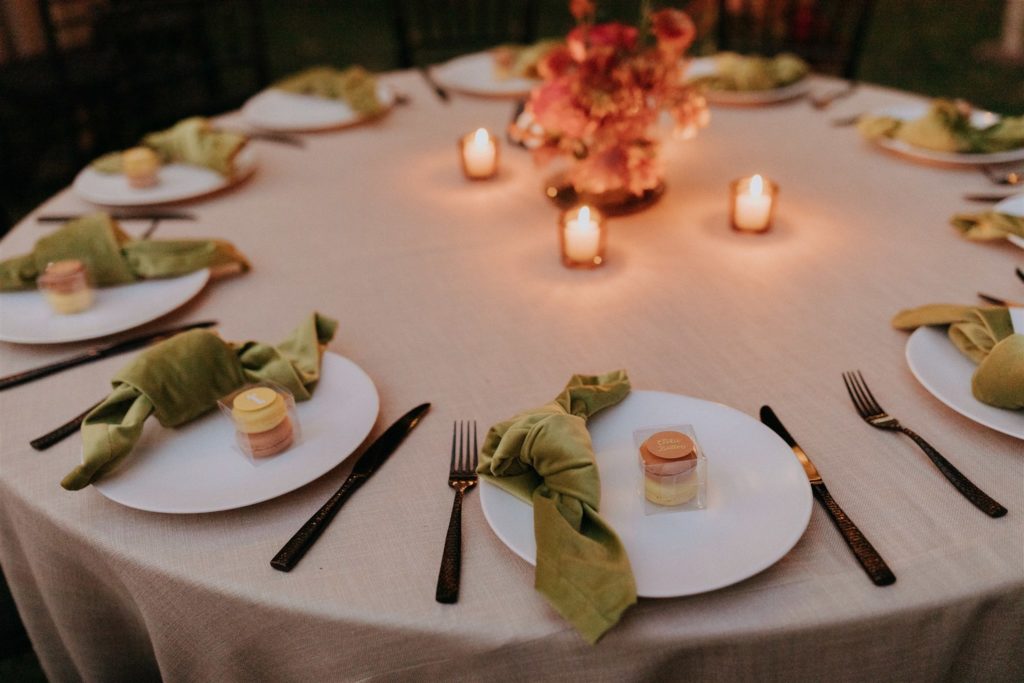 mid-century inspired wedding reception with black chivari chairs, green linen napkins and bright floral centerpieces