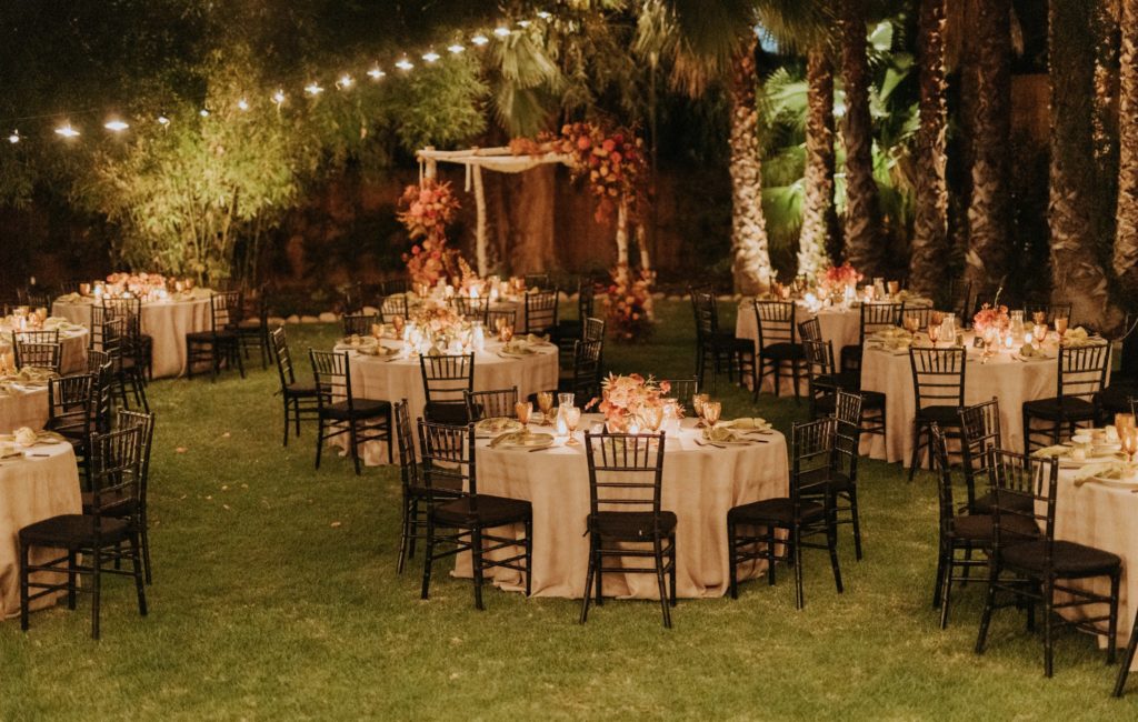 mid-century inspired wedding reception with black chivari chairs, green linen napkins and bright floral centerpieces