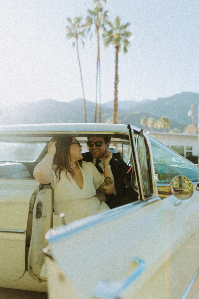 engaged couple sitting in white vintage car during engagement photo session in Palm Springs