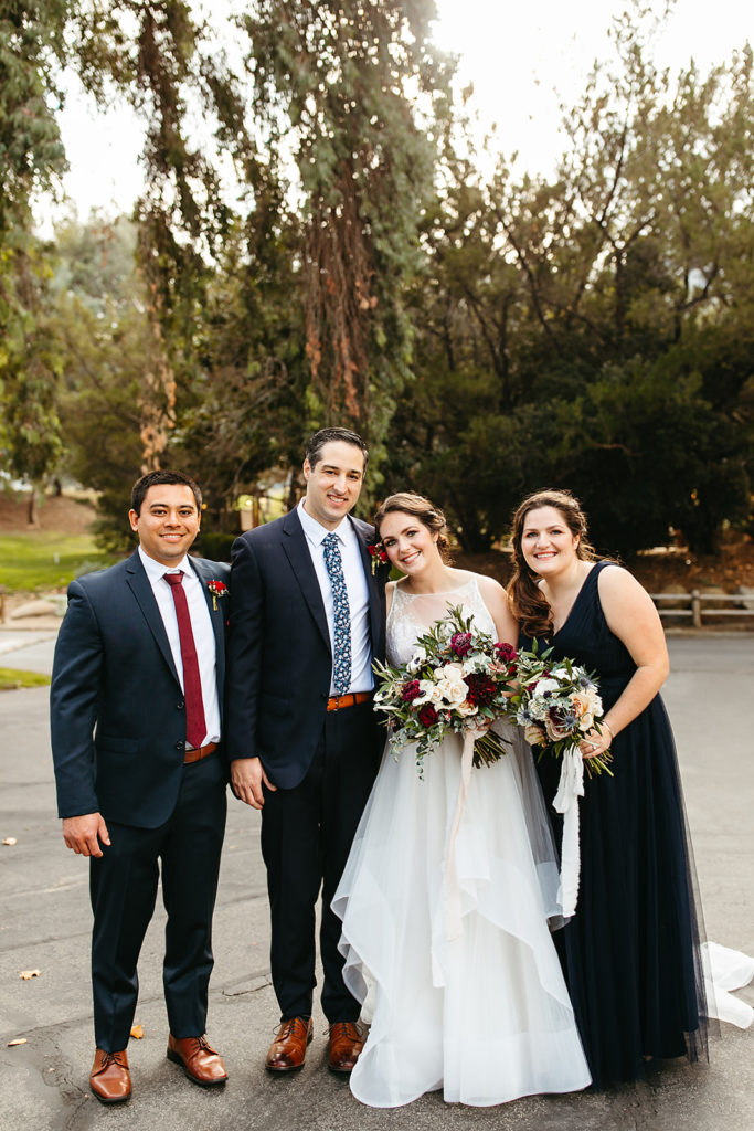 small wedding party stands with bride and groom before hygge wedding at Temecula Creek Inn