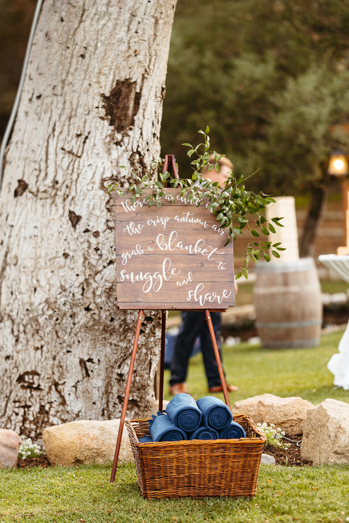 basket with blue blankets and wooden sign for guests