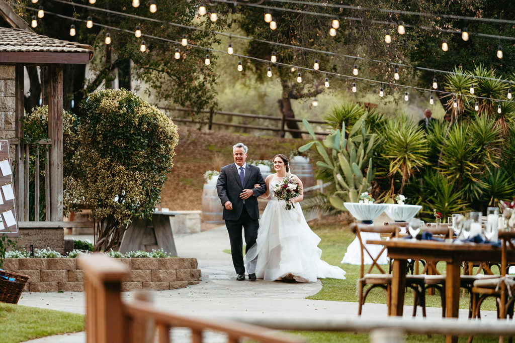bride walks down the aisle with father at Temecula Creek Inn