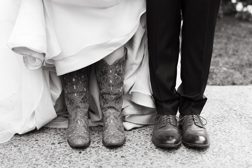 bridal cowboy boots and groom shoes in black and white photo