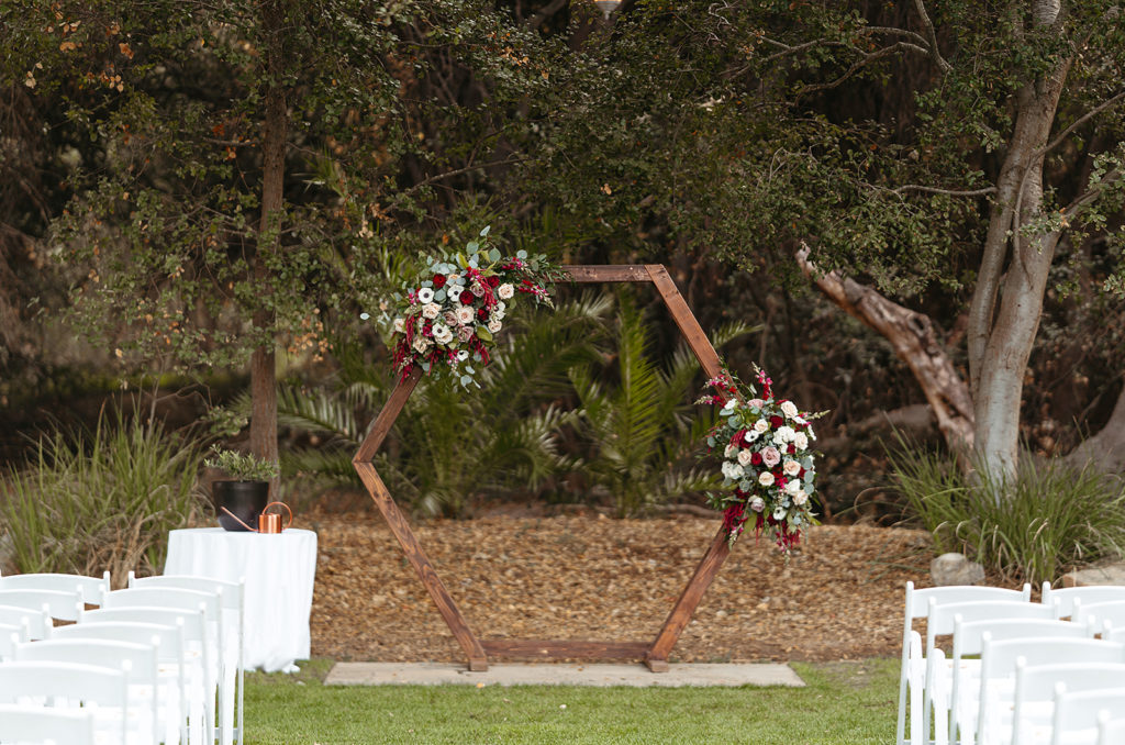 hygge wedding ceremony at Temecula Creek Inn with white chairs and wooden geometric ceremony arch