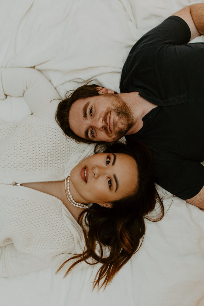 engaged couple laying in bed during engagement photo session in Palm Springs
