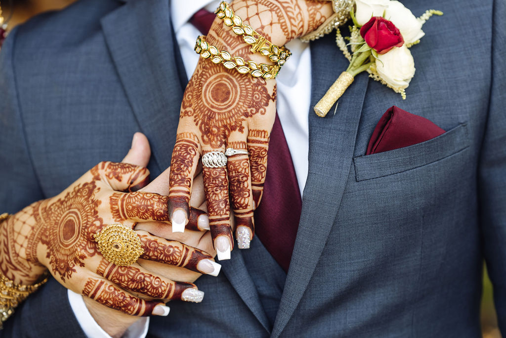 Indian bride with henna tattoos shows off wedding rings