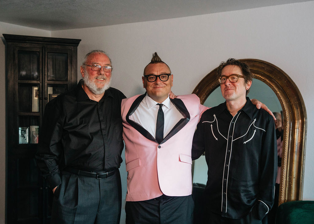 groom in pink suit jacket stands with groomsmen 