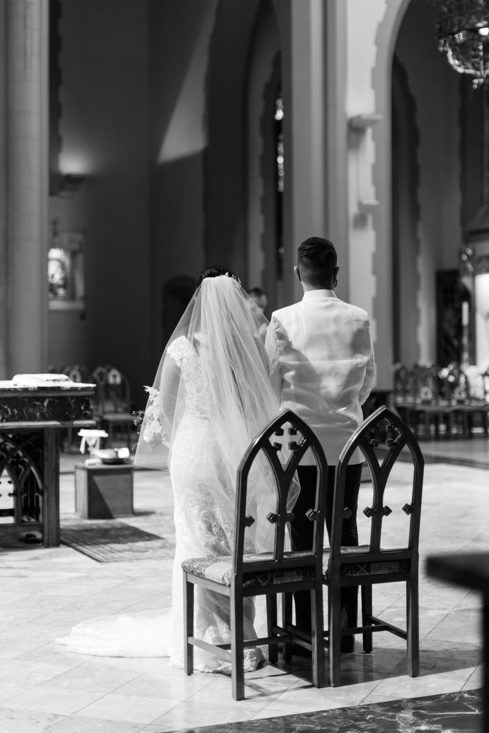 black and white photo of bride and groom standing at the altar for Catholic Church wedding ceremony
