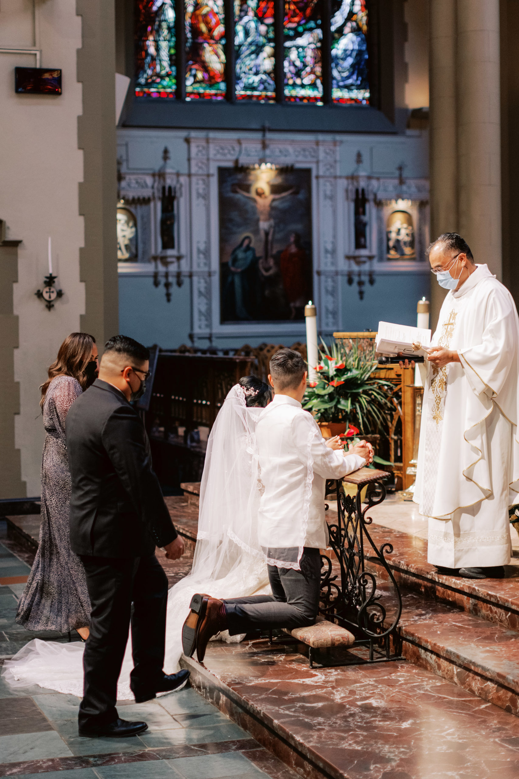 bride and groom kneeling at altar in Catholic Church wedding ceremony