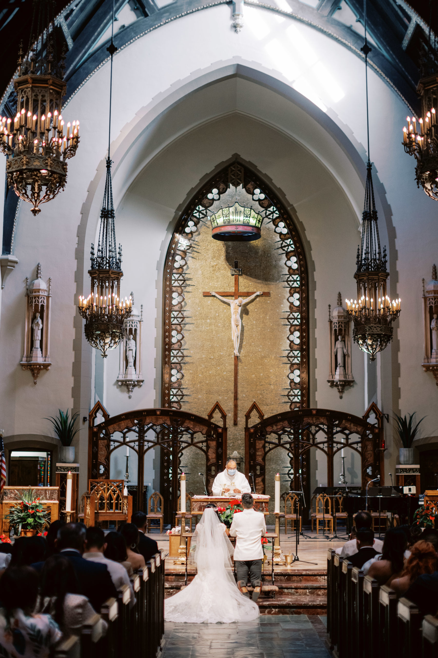 bride and groom kneeling at altar in Catholic Church wedding ceremony