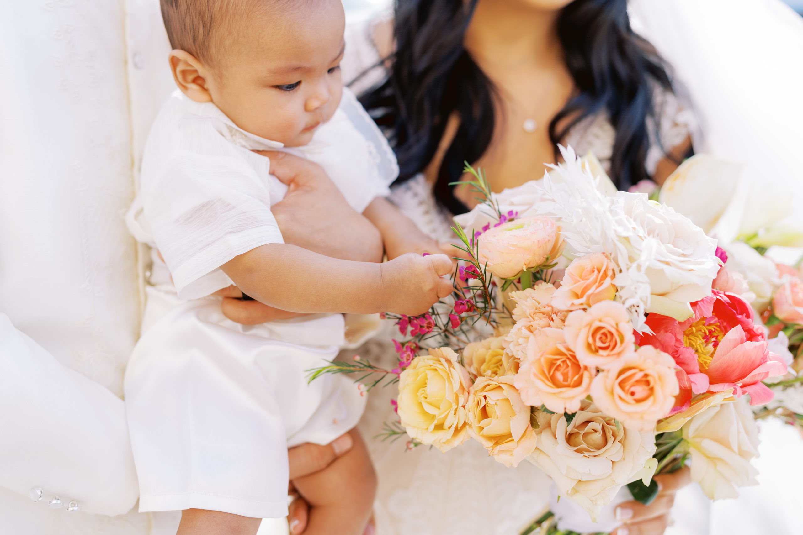 baby plays with bridal bouquet