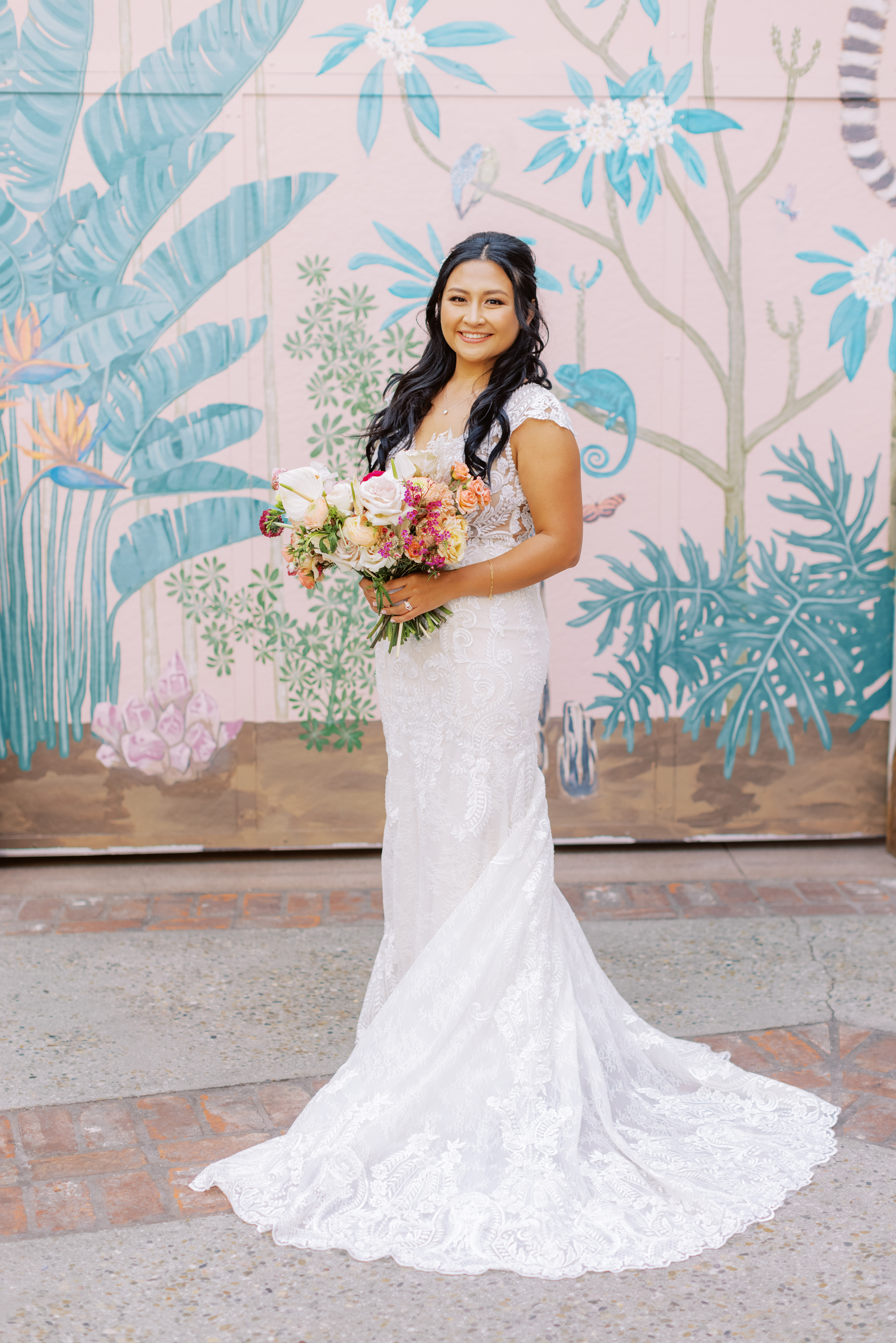 bride in lace dress holding tropical bouquet during cocktail hour at The Valentine DTLA 