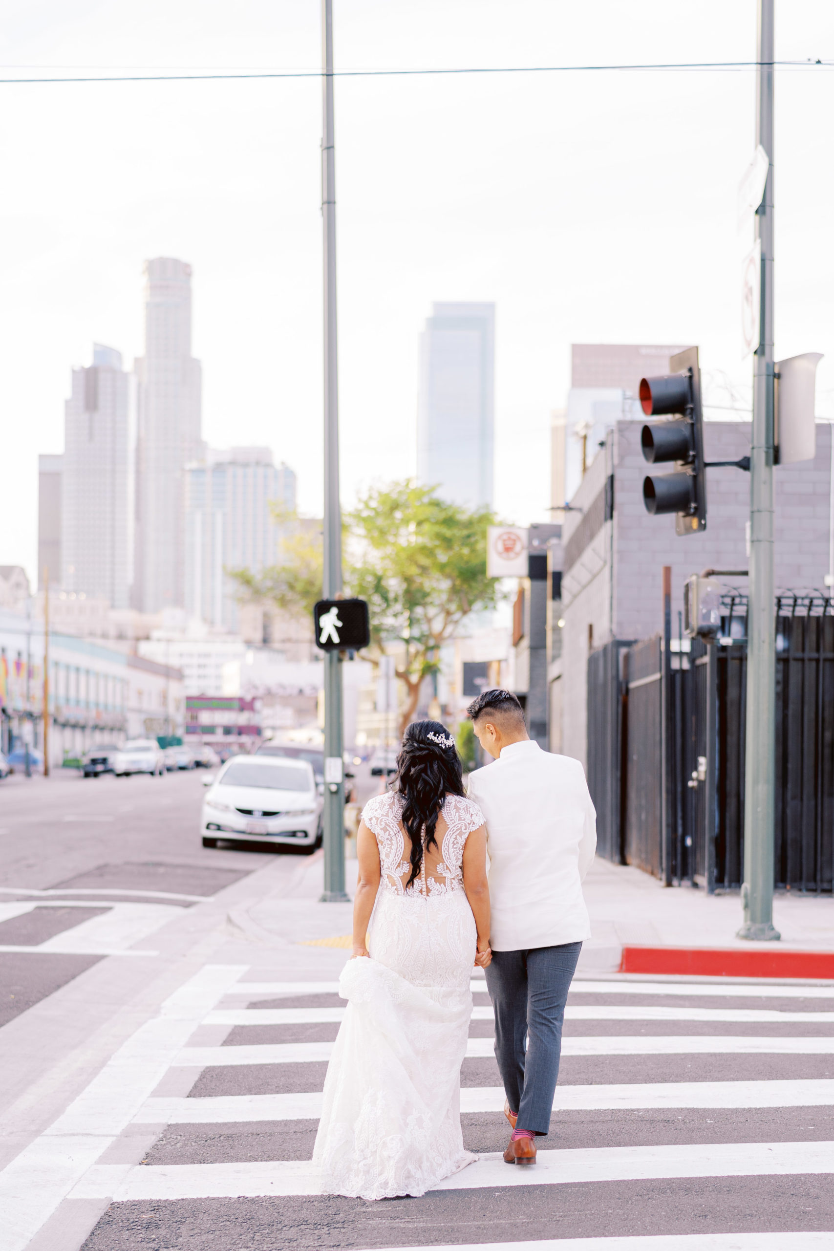 bride and groom walk hand in hand down the street in DTLA
