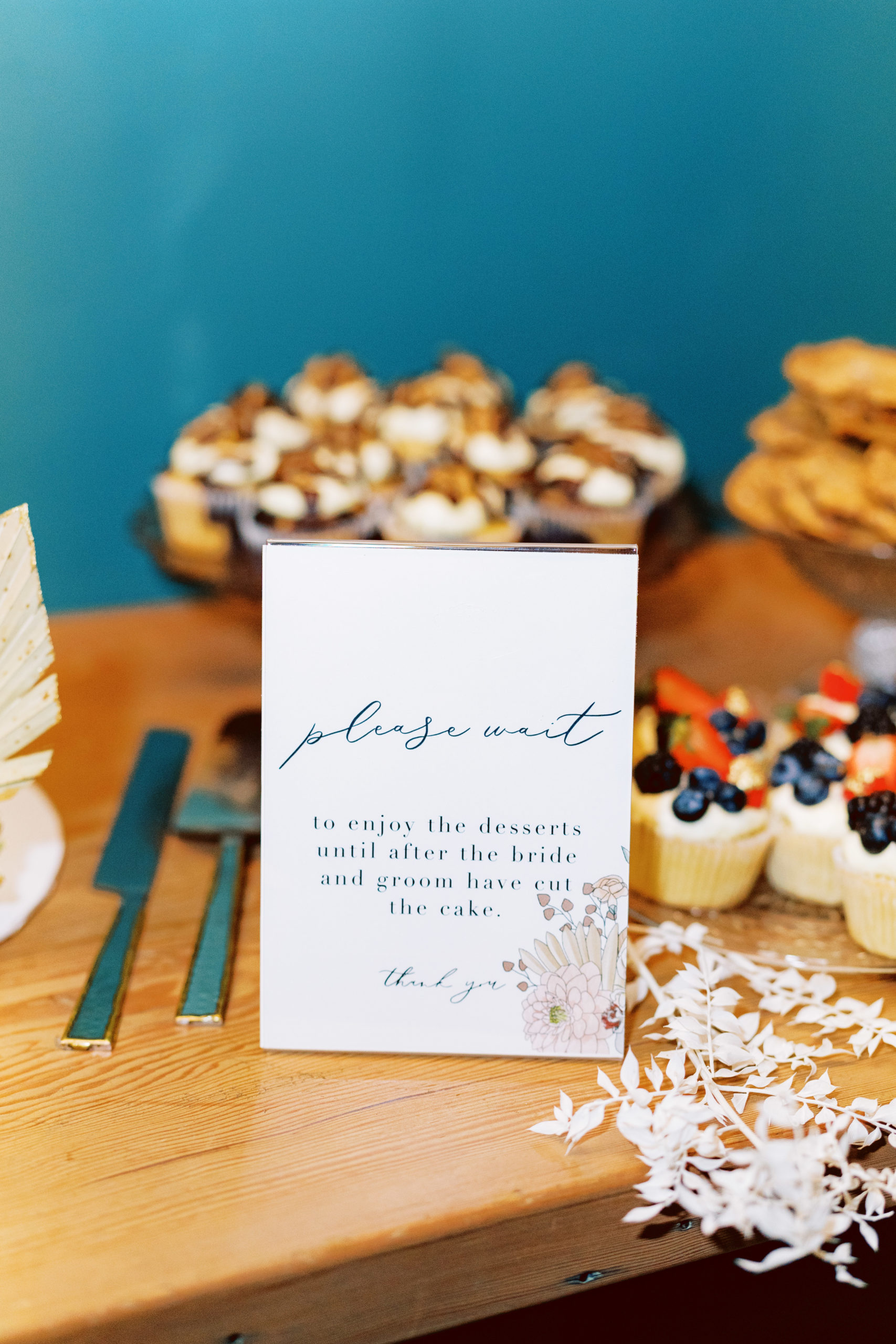 dessert table sign instructing guests to wait to eat the desserts
