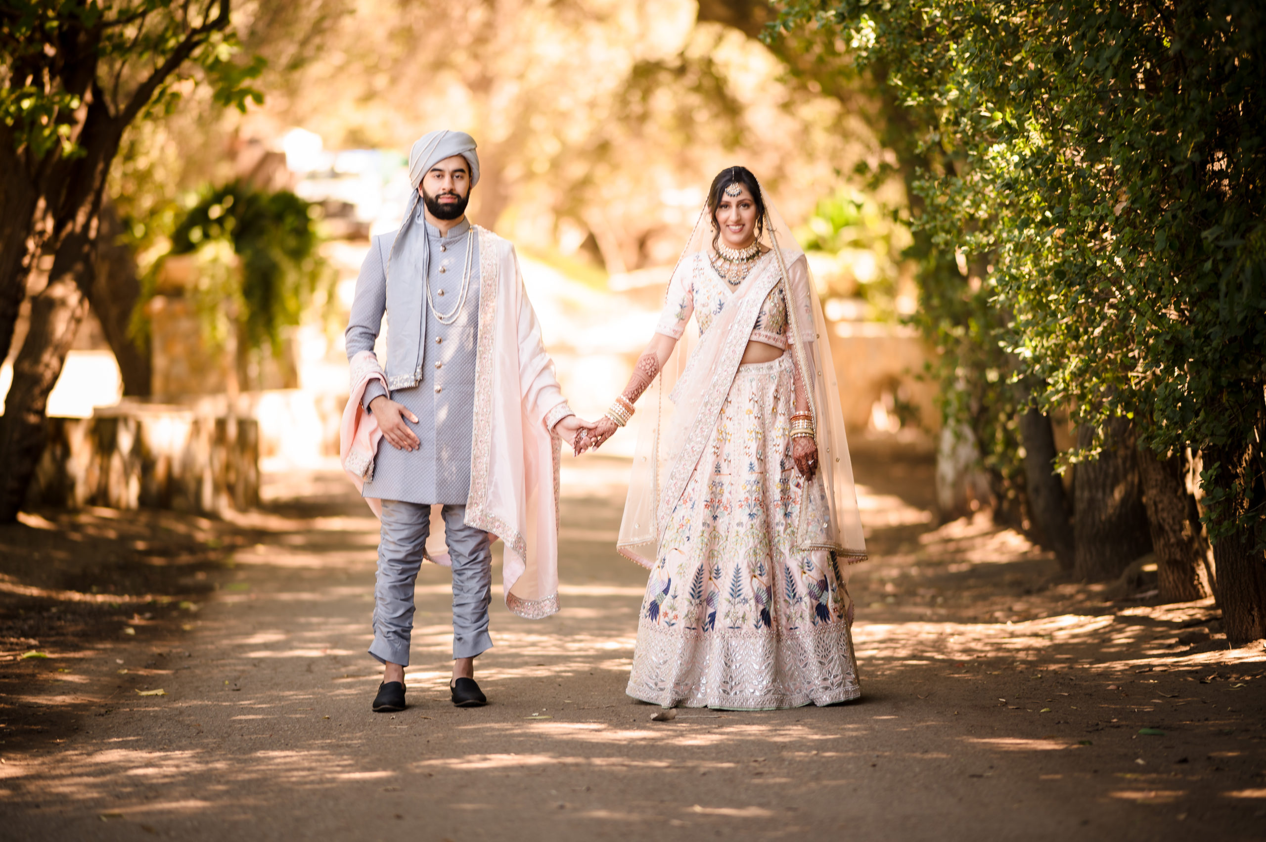 Indian bride with pink sari and groom with grey sherwani and