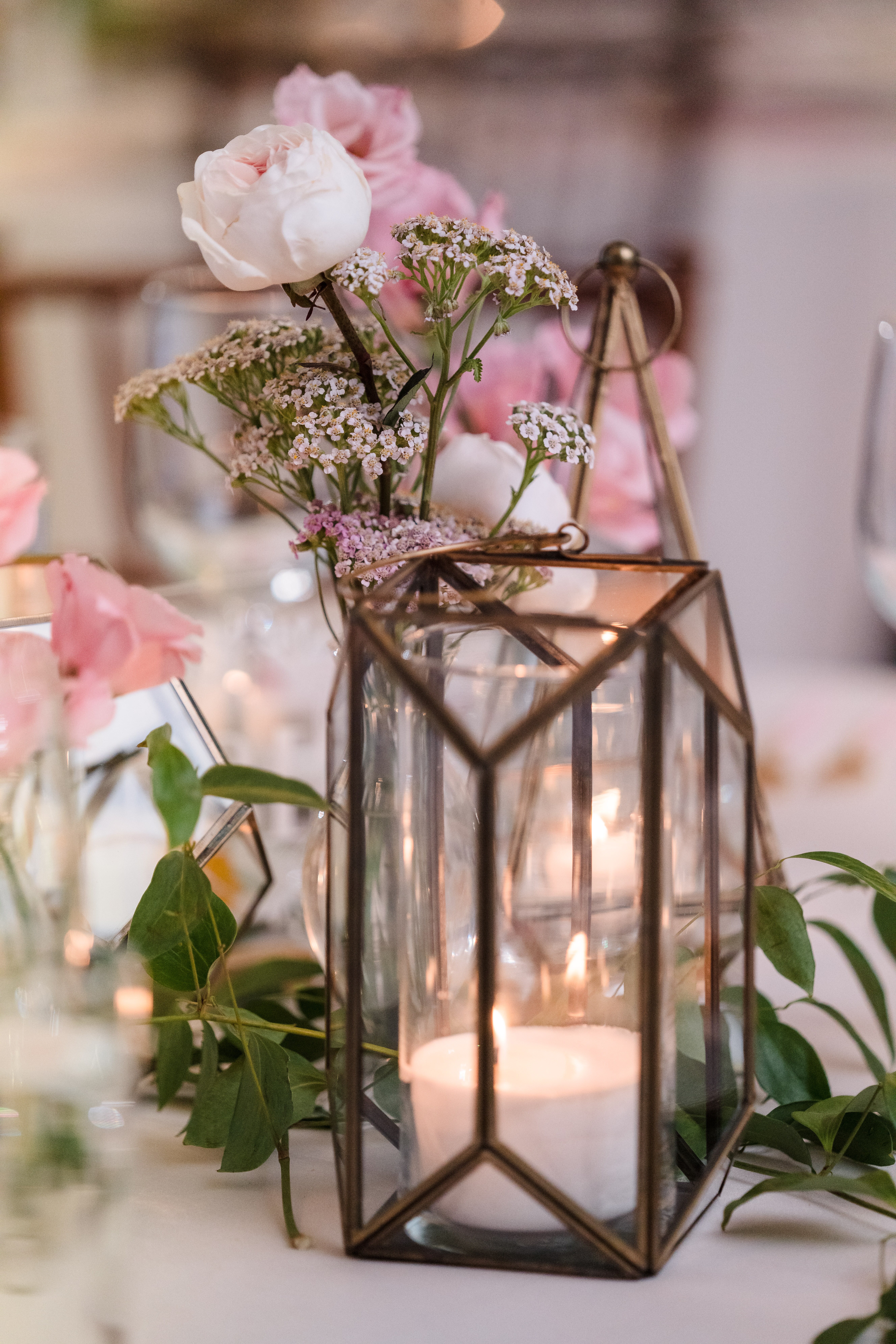 gold lantern with candle at pink infused wedding reception 