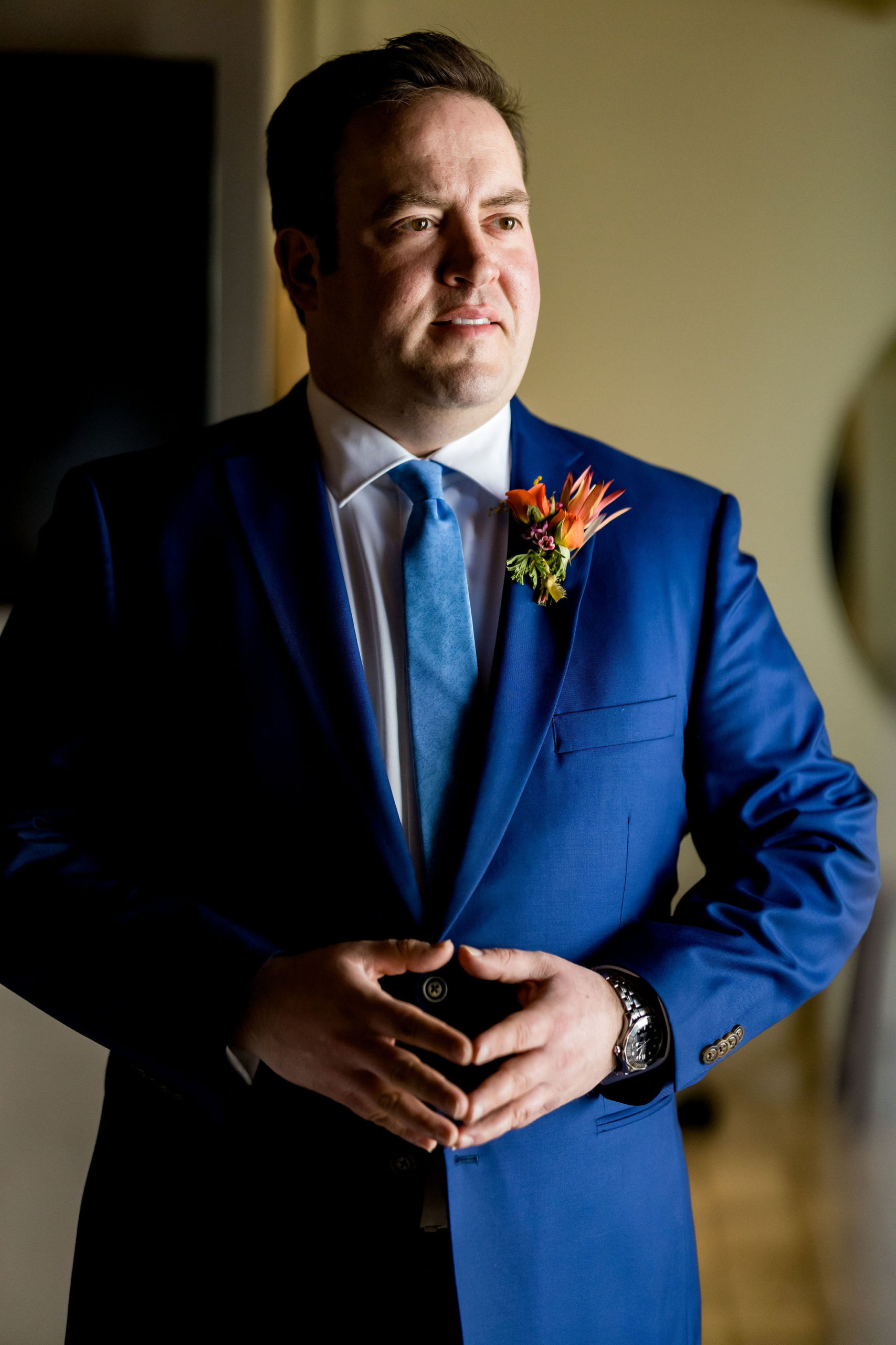 groom in bright blue suit with blue tie and bright floral boutonniere 