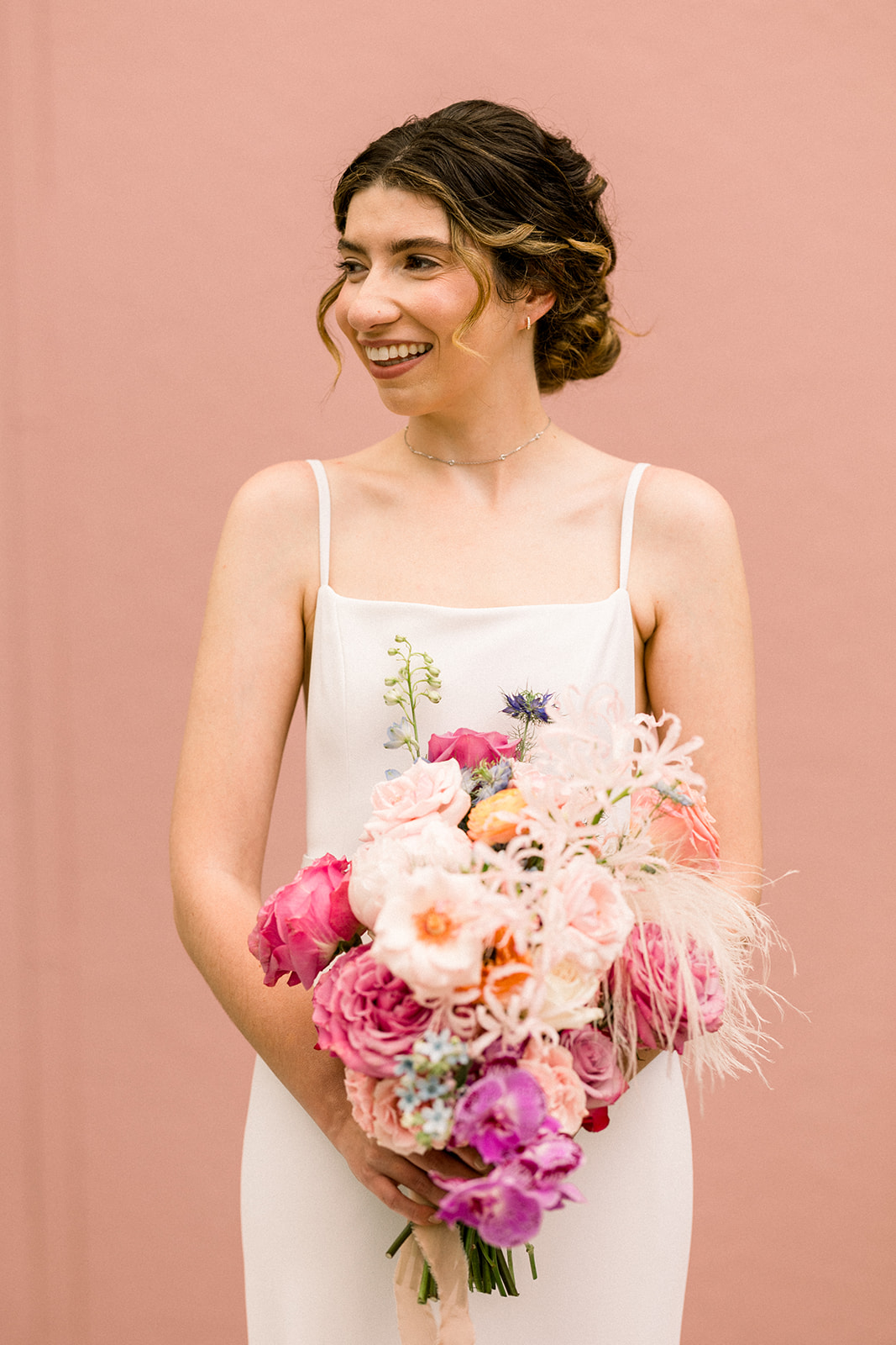 bride in contemporary wedding dress holds pastel bridal bouquet