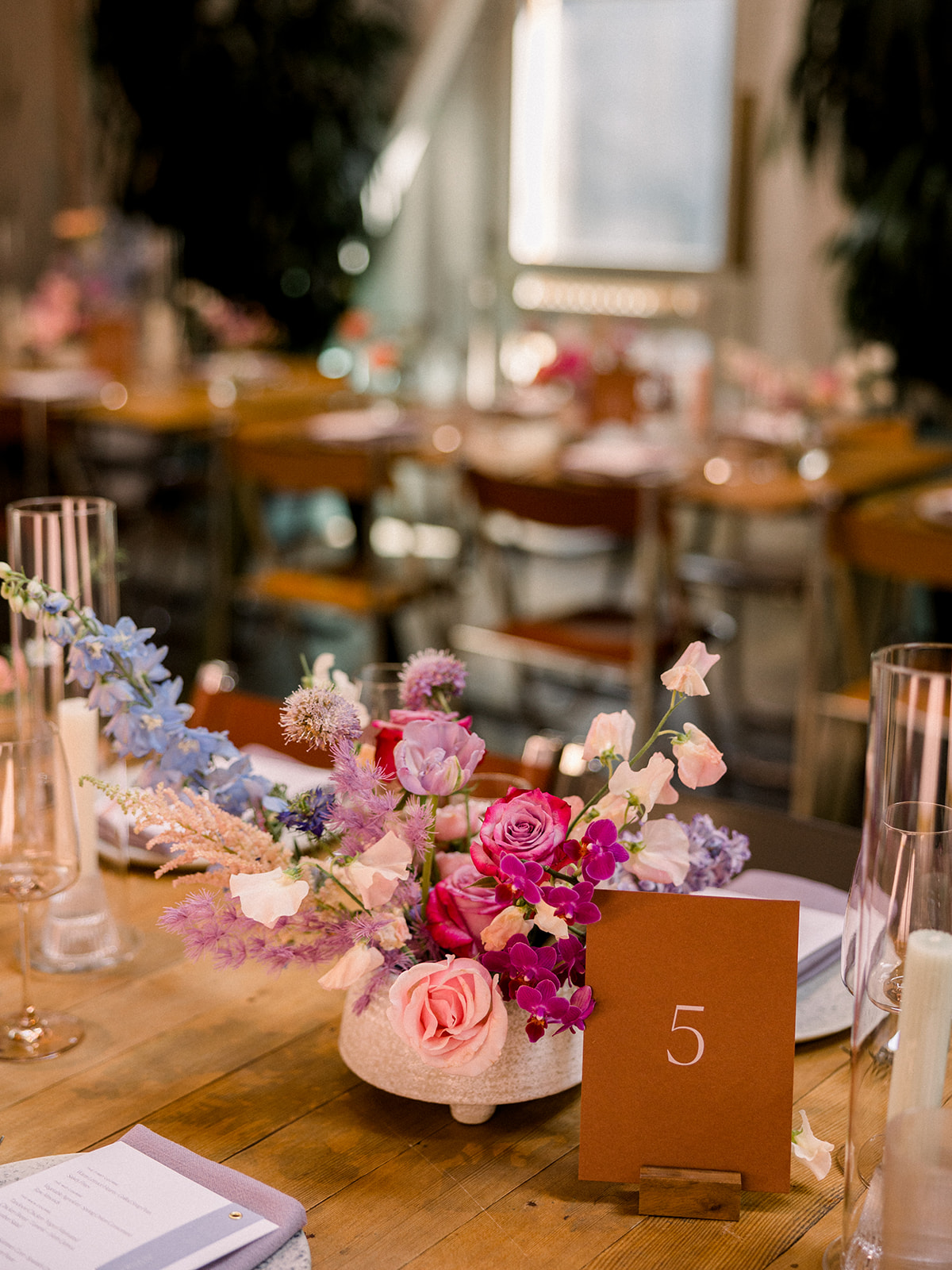 contemporary wedding reception at The Grass Room with pastel floral arrangements on tables and simple card stock table numbers