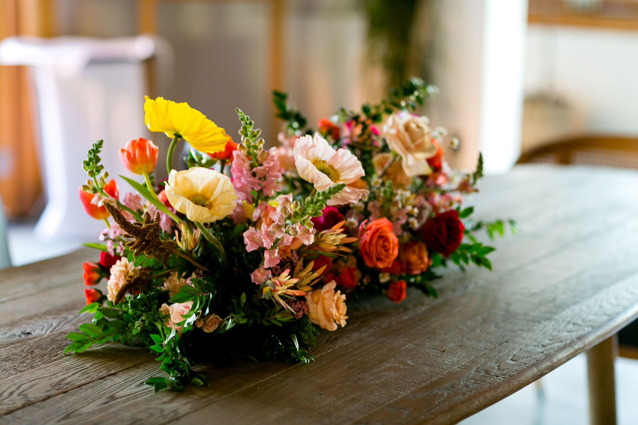 bright floral centerpiece on top of wooden farm table
