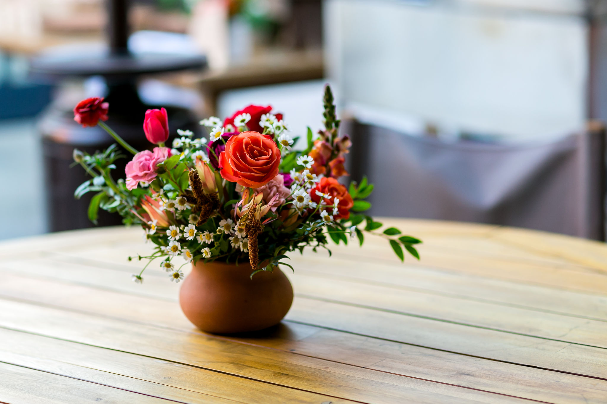 bright floral centerpiece in terracotta pot