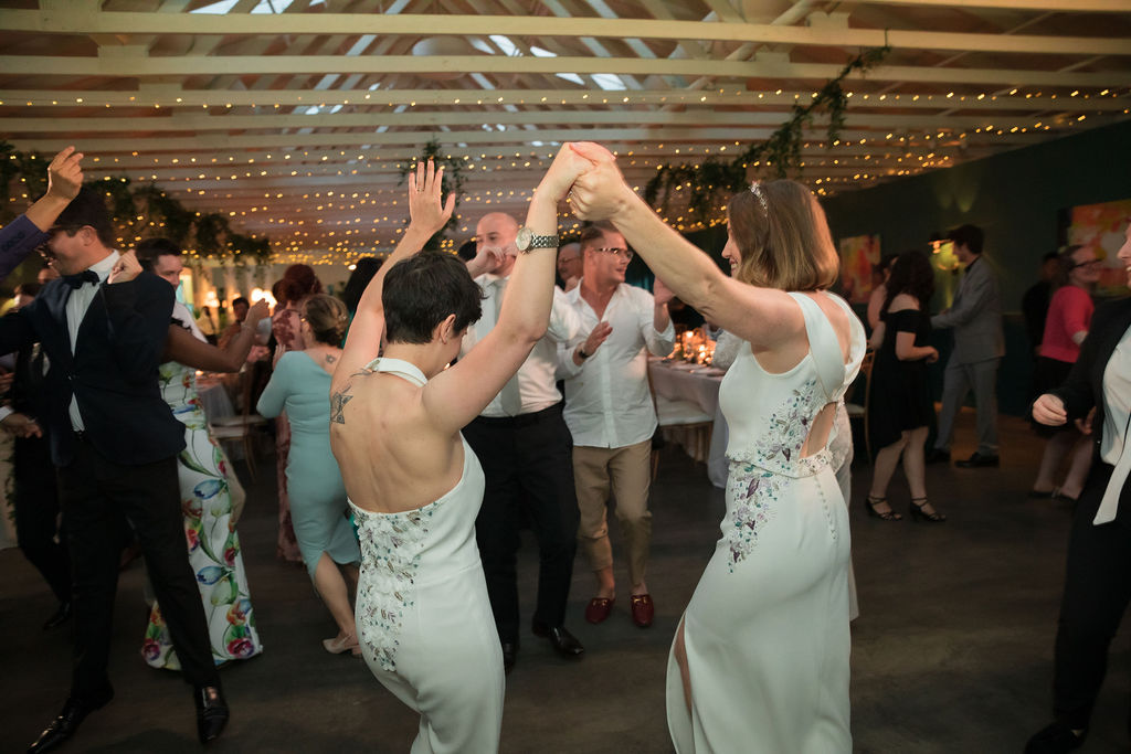 two brides dance together during wedding reception 