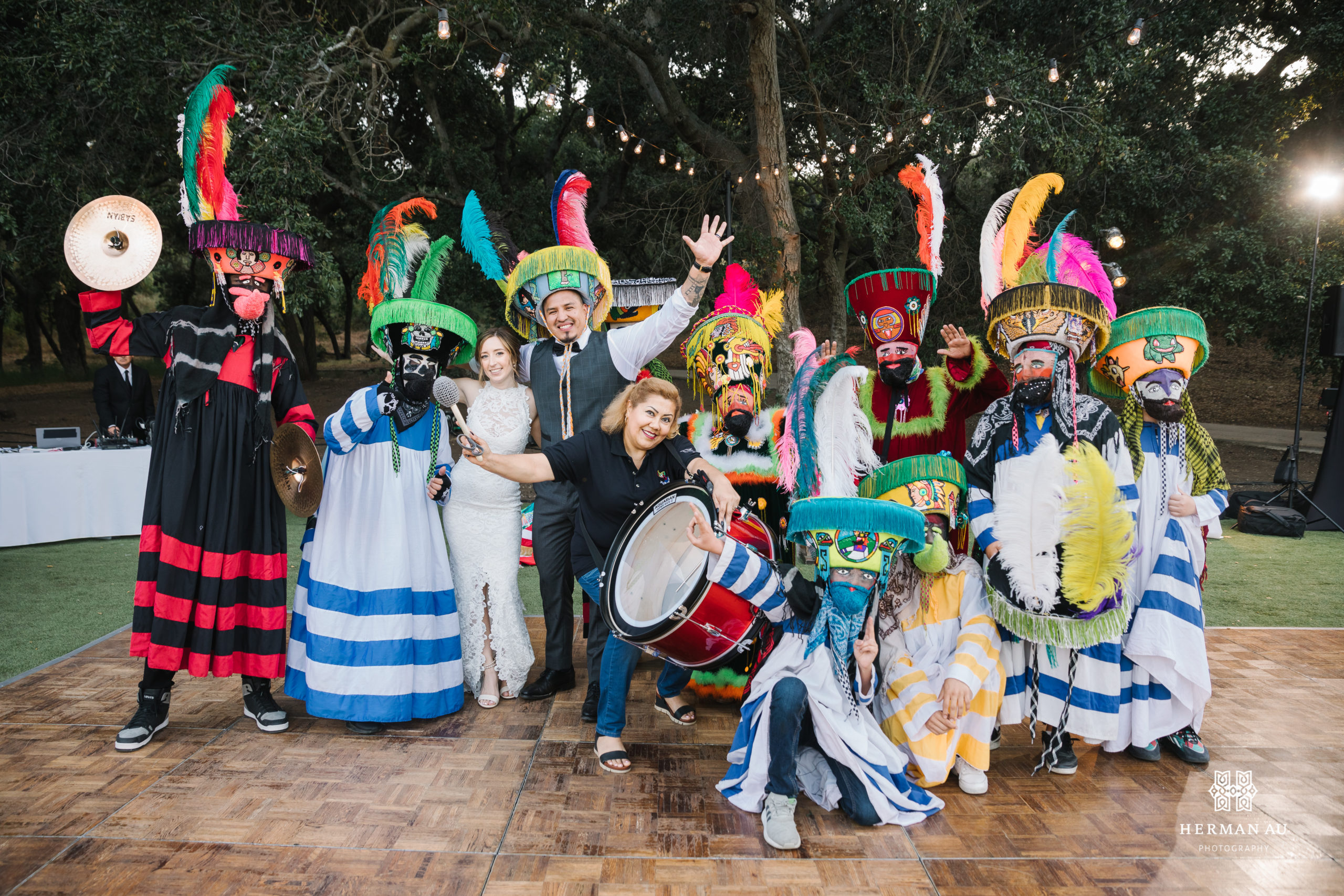 bride and groom take photo with traditional Mexican wedding parade members during festive wedding reception at Saddlerock Ranch