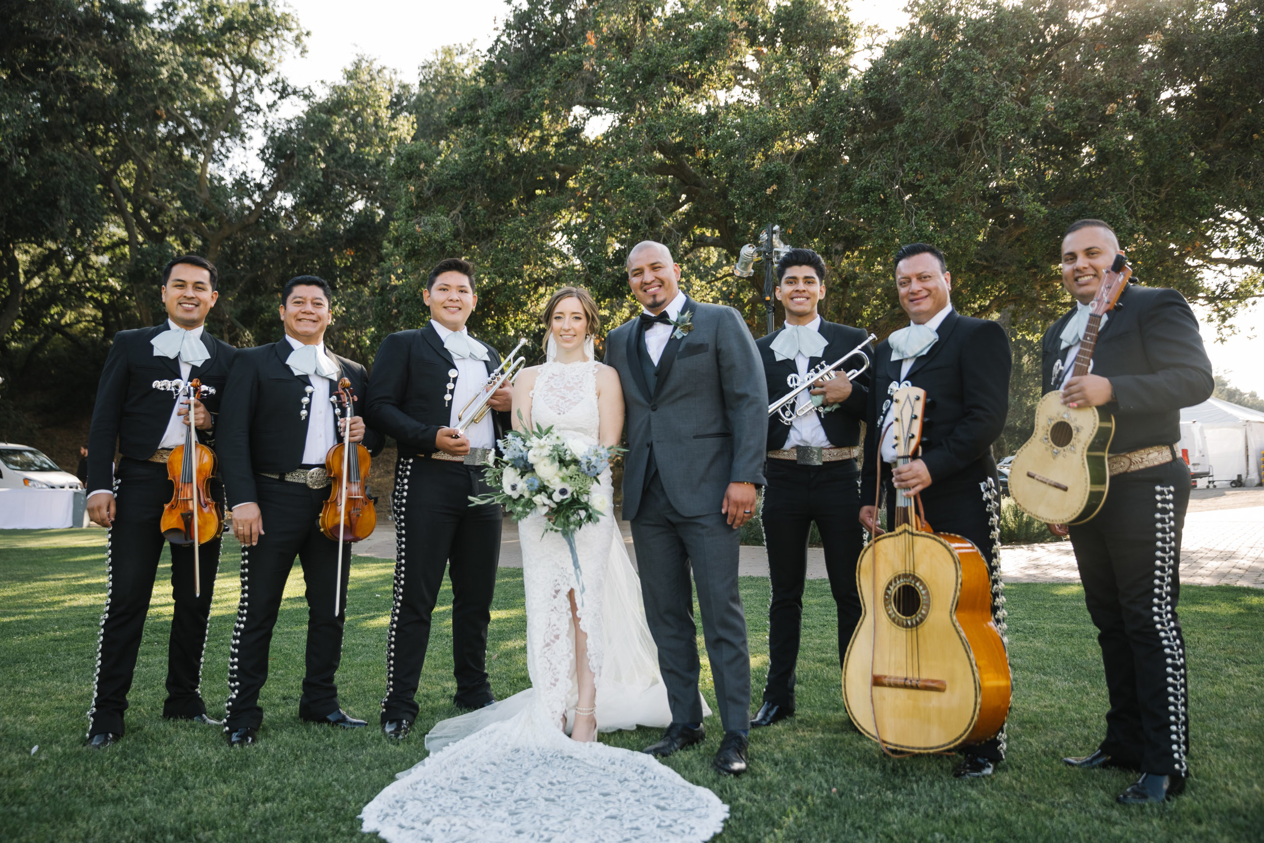 bride and groom stand with mariachi band during festive wedding reception at Saddlerock Ranch