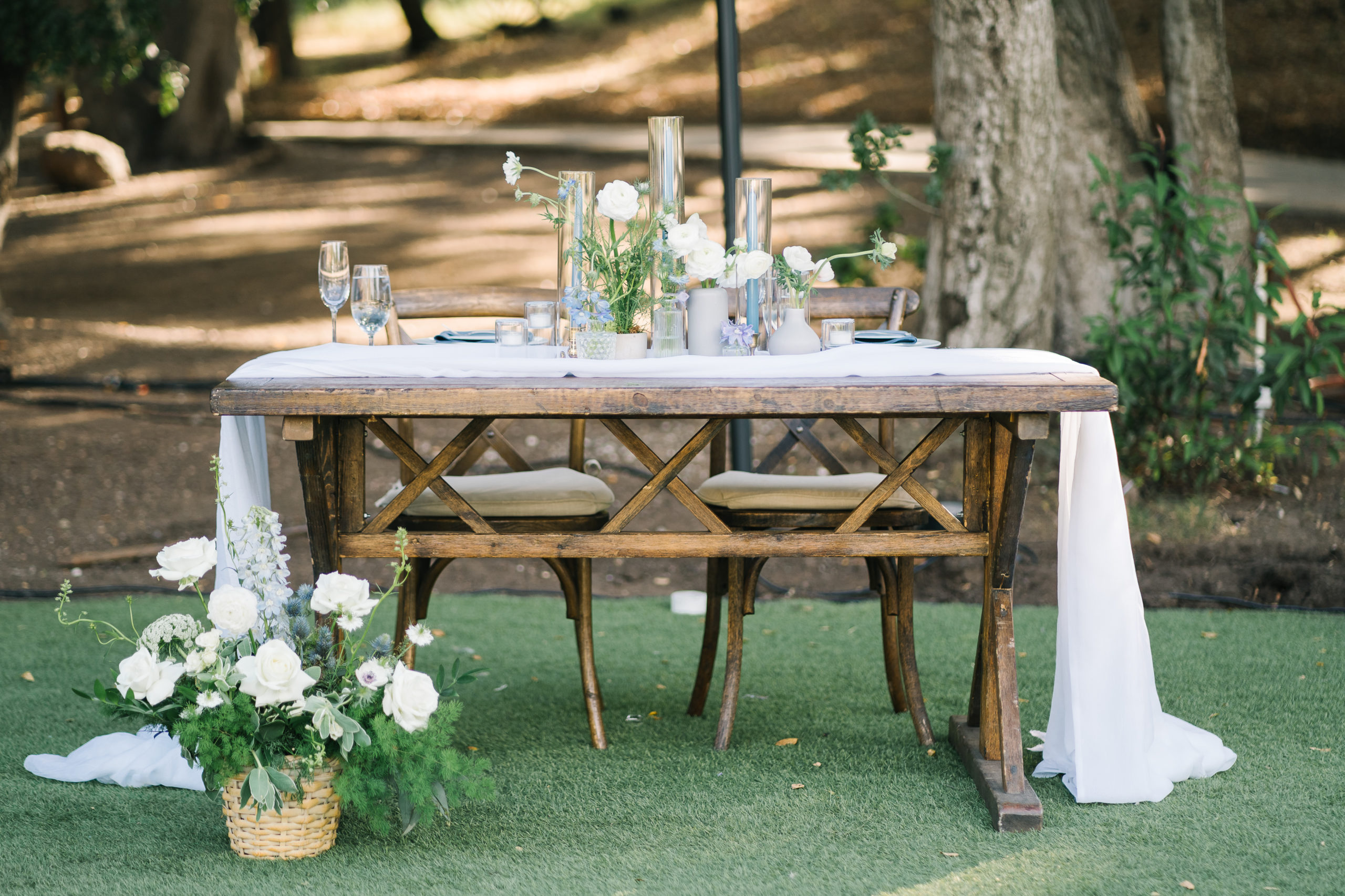 romantic blue toned wedding reception at Saddlerock Ranch with farm tables, wooden chairs, and modern details 