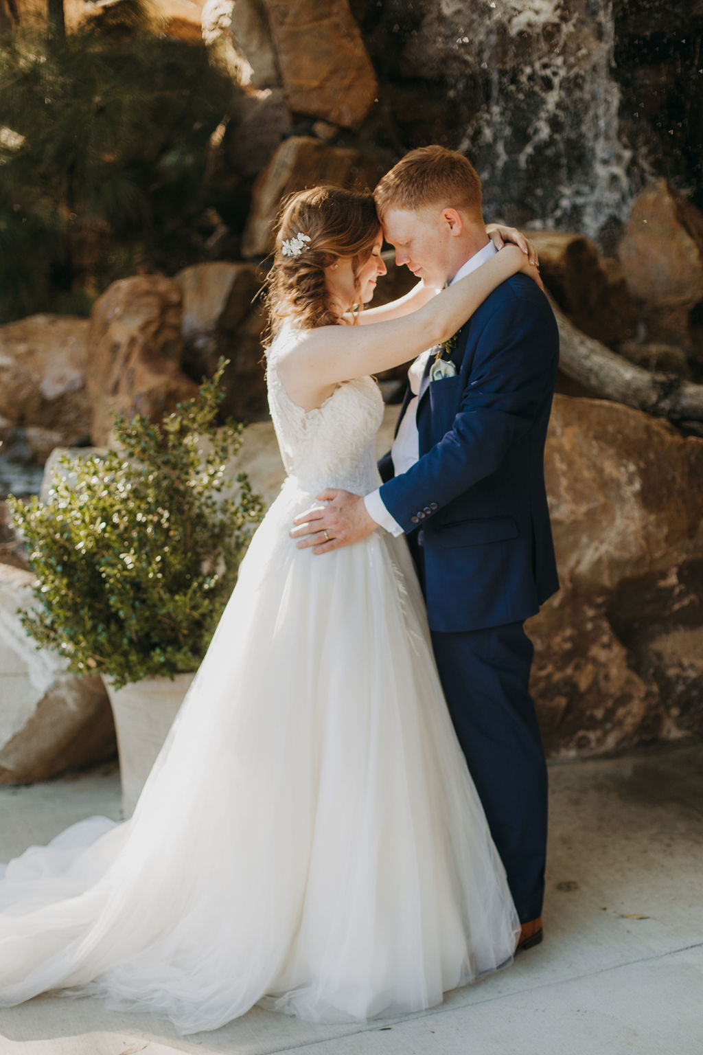 bride in v-neck embellished tulle ballgown wedding dress with groom groom in navy blue suit and green bowtie portrait shots at Calamigos Ranch