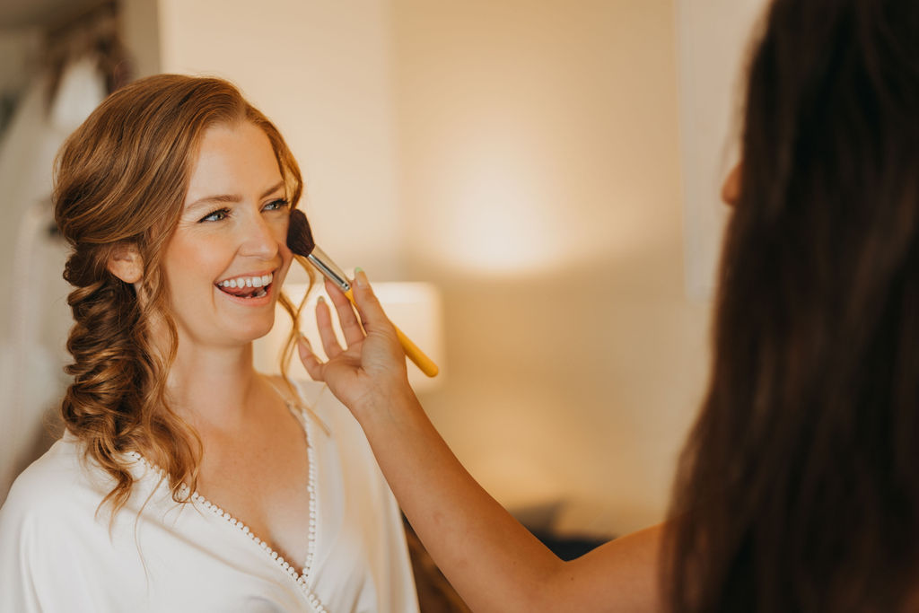 red haired bride getting makeup before wedding