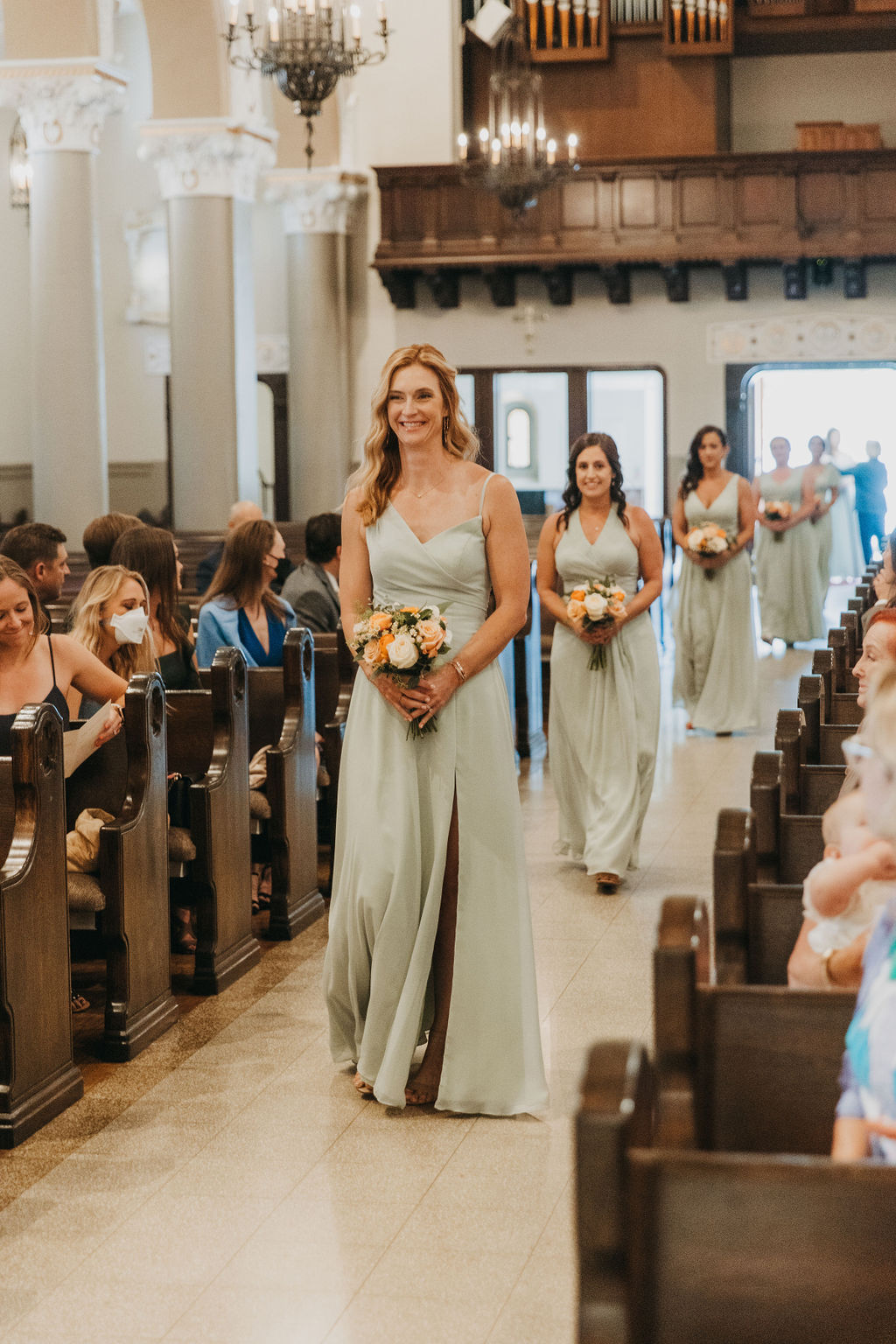bridesmaids in soft mint green dresses walking down aisle