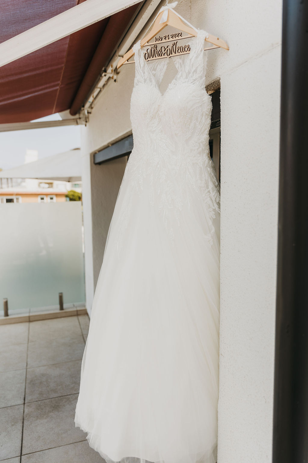 v neck tulle ballgown wedding dress hanging on wooden hanger