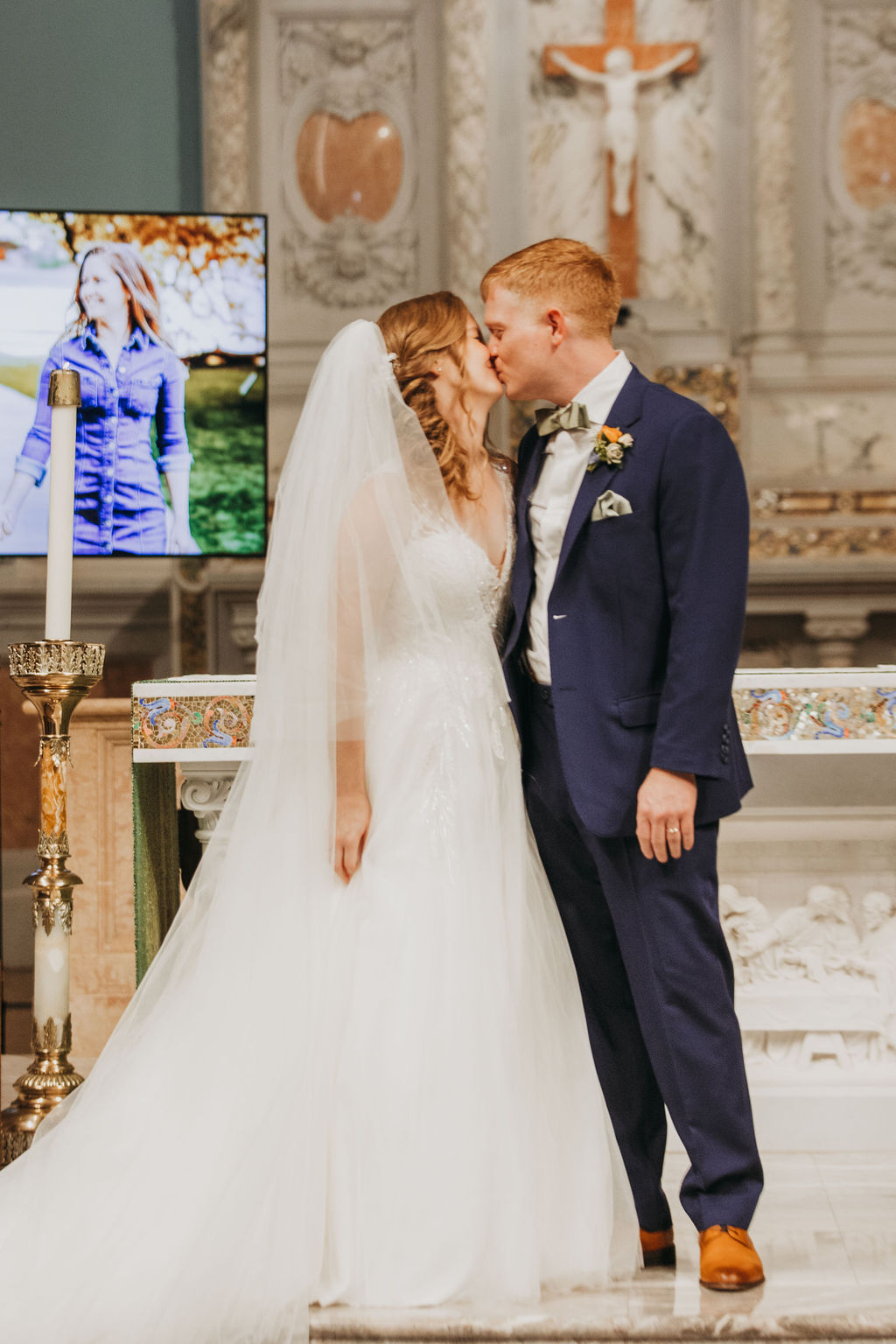 bride and groom first kiss during wedding ceremony at Saint Monica Catholic Church