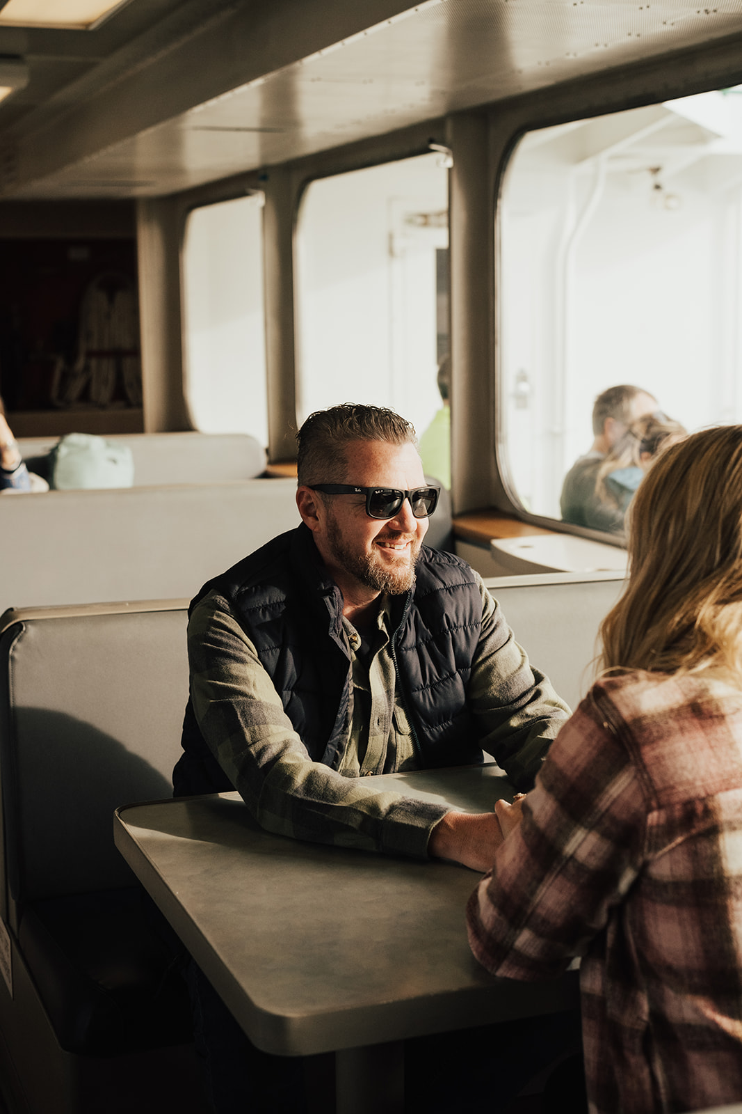 couple laughing on Seattle ferry during fall PNW engagement photo session