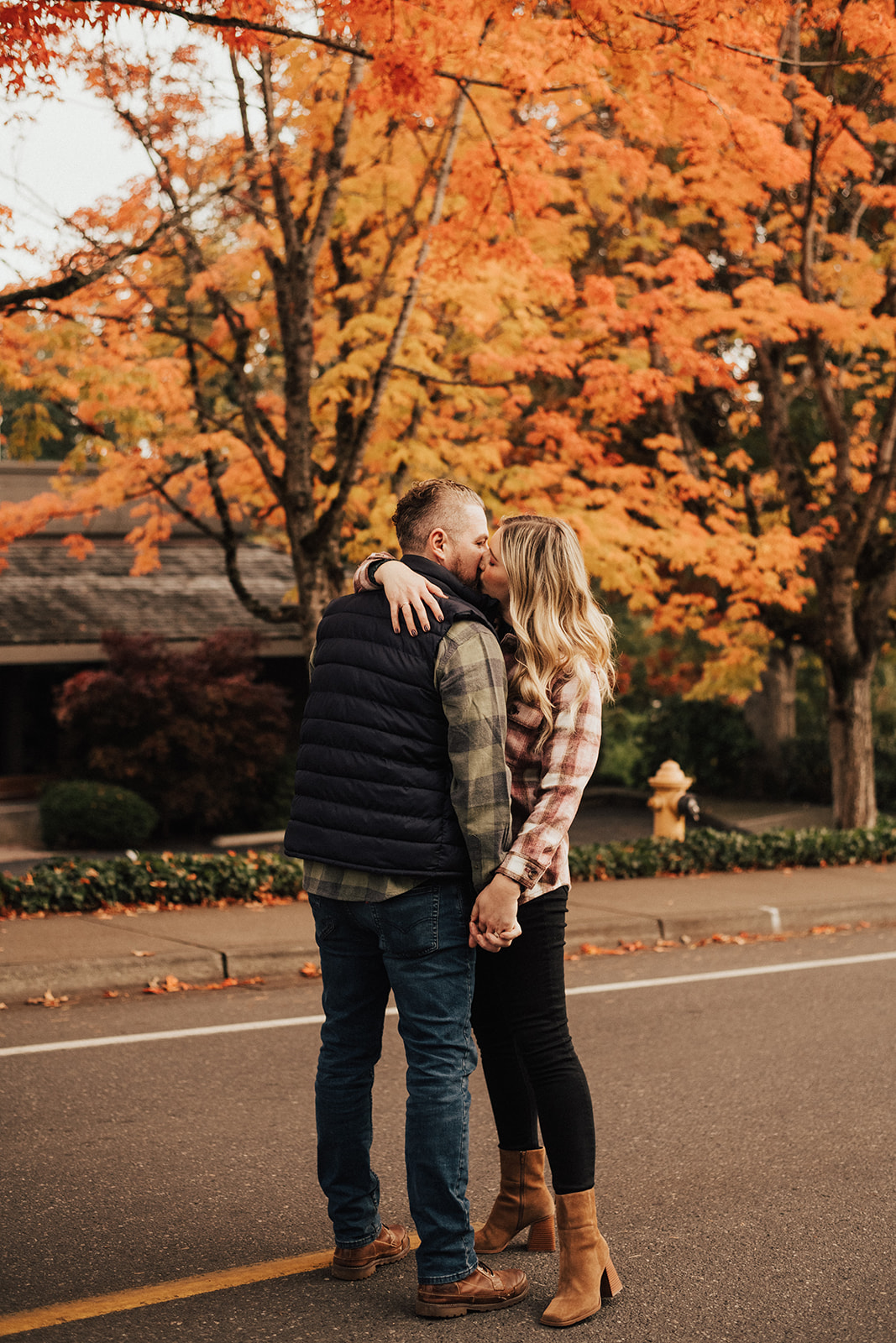 Newly engaged couple in plaid shirts kissing in Seattle during the fall 