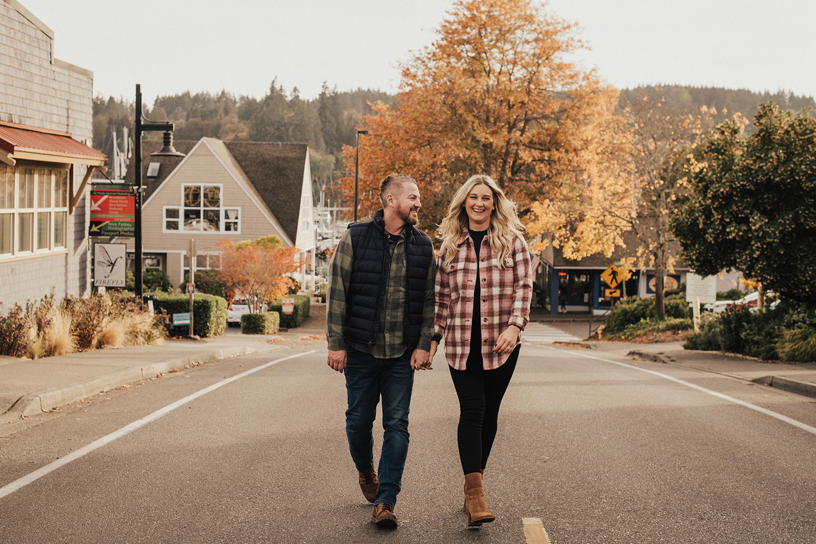 fall engagement photo session with couple holding hands while walking down the street in Seattle