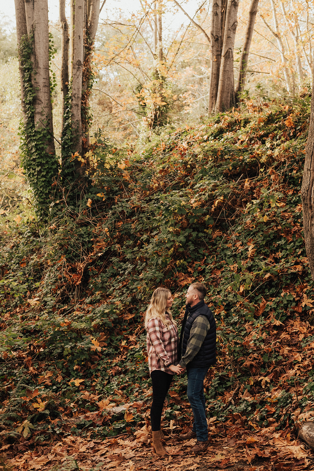 PNW fall engagement photo session with couple holding hands in wooded area