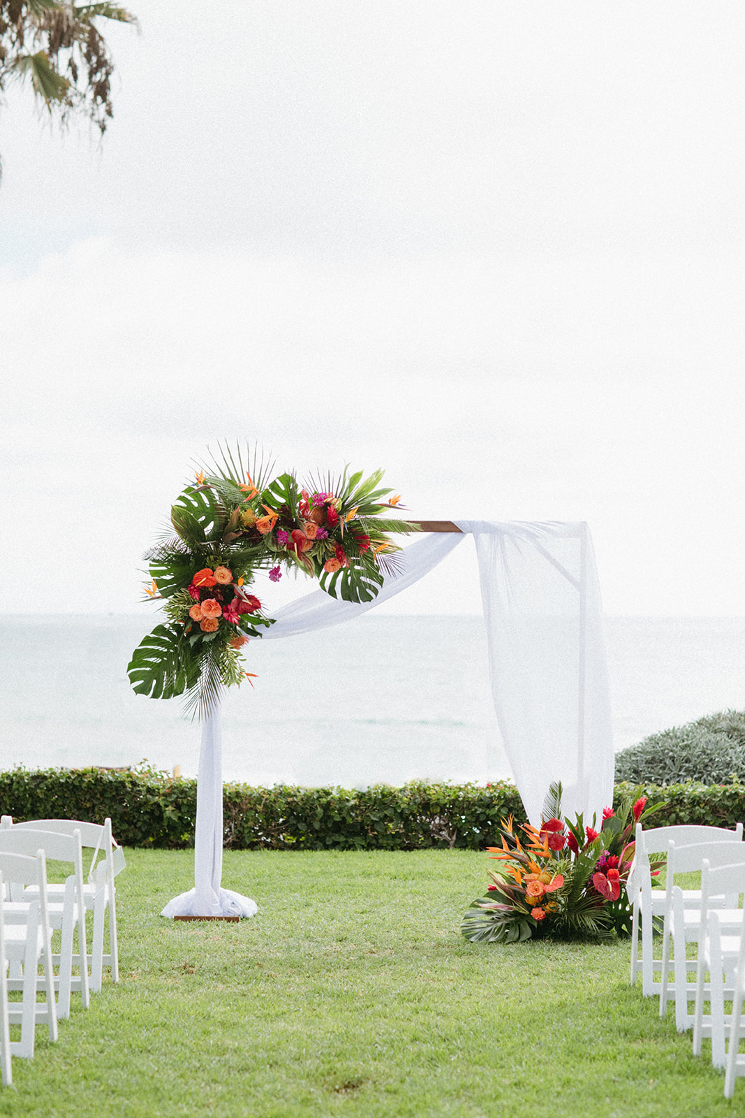 outdoor tropical wedding ceremony at Ole Hanson Beach Club with ocean view and white chairs
