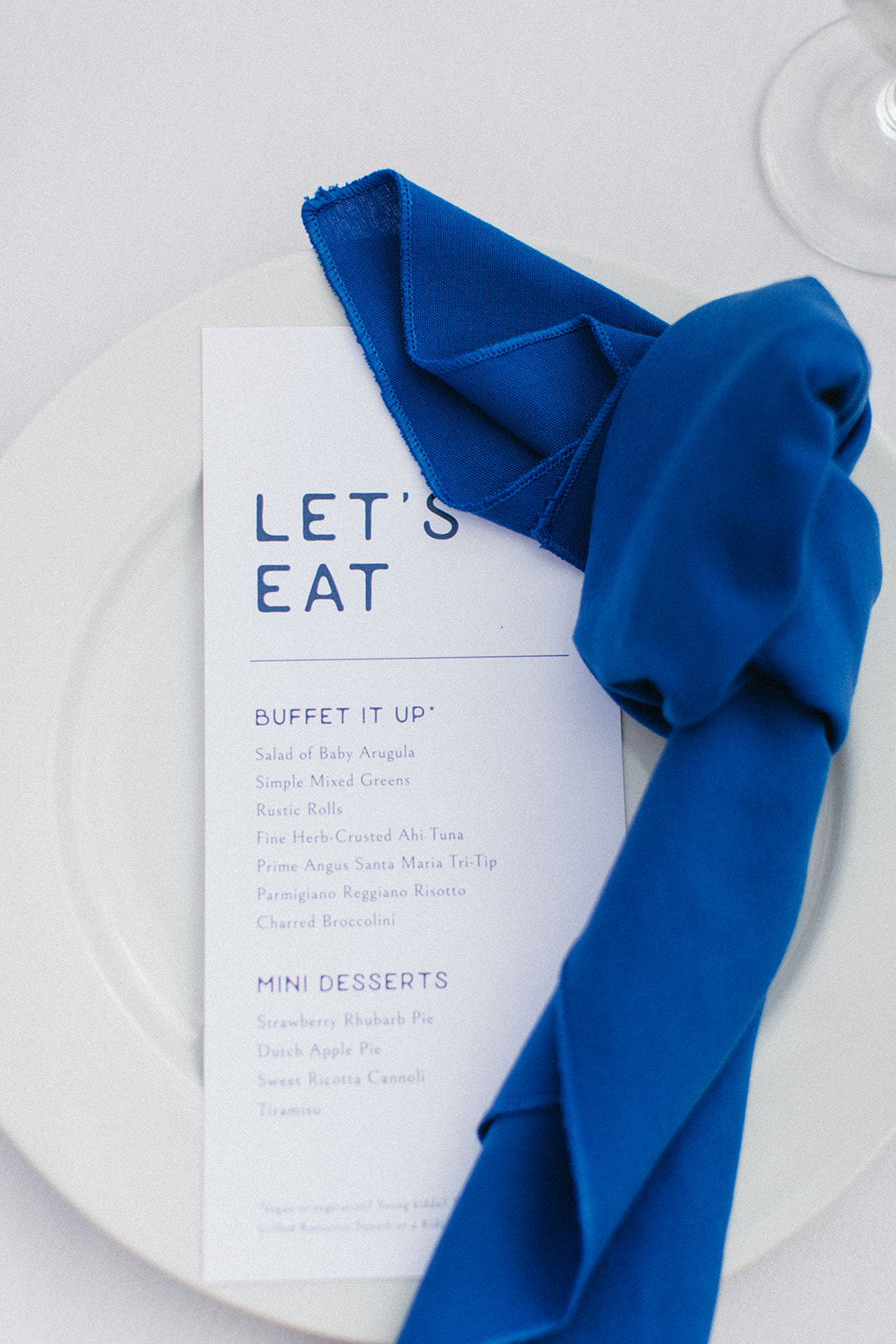 blue napkin on top of menu card in matching blue font