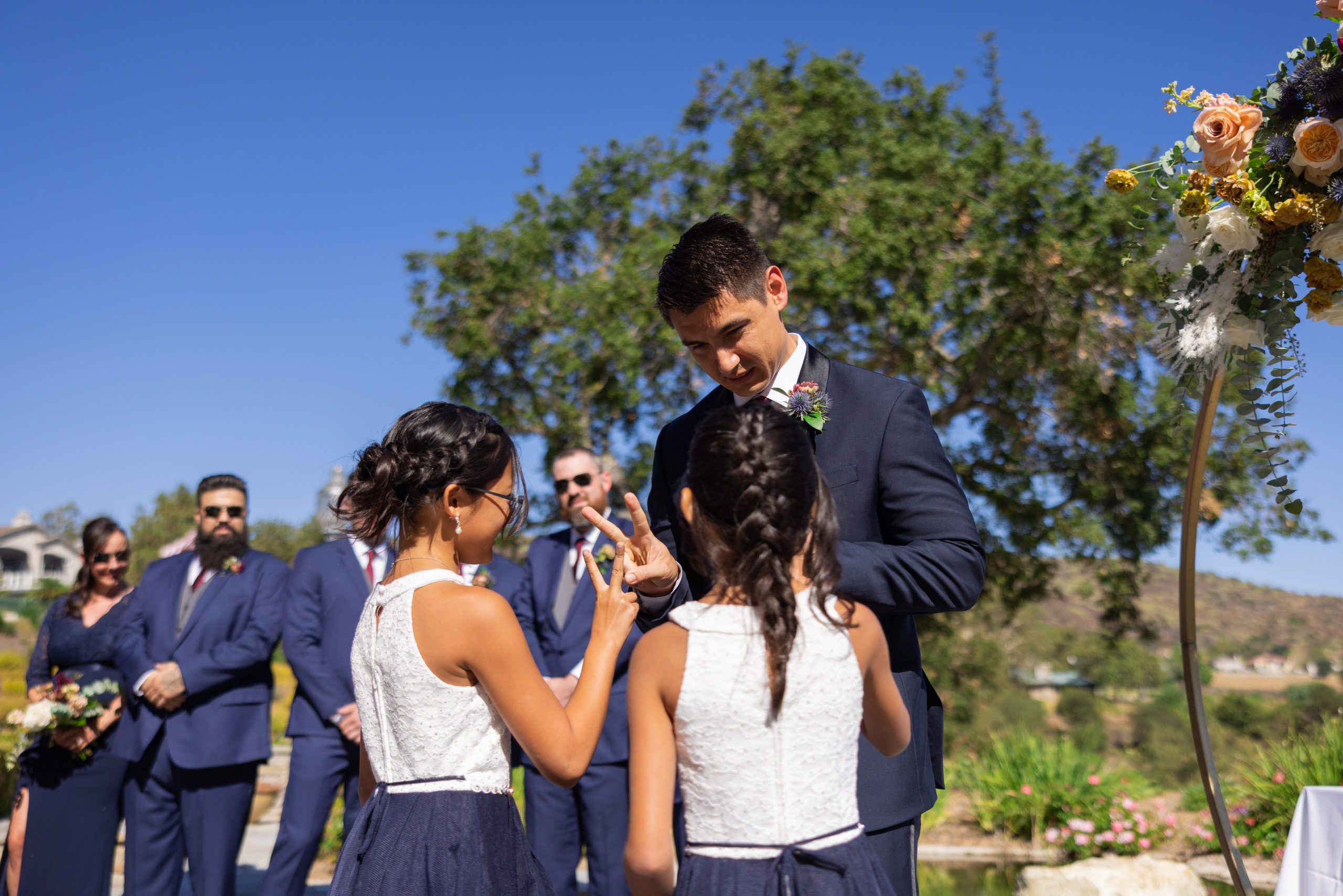 flower girls give groom peace sign