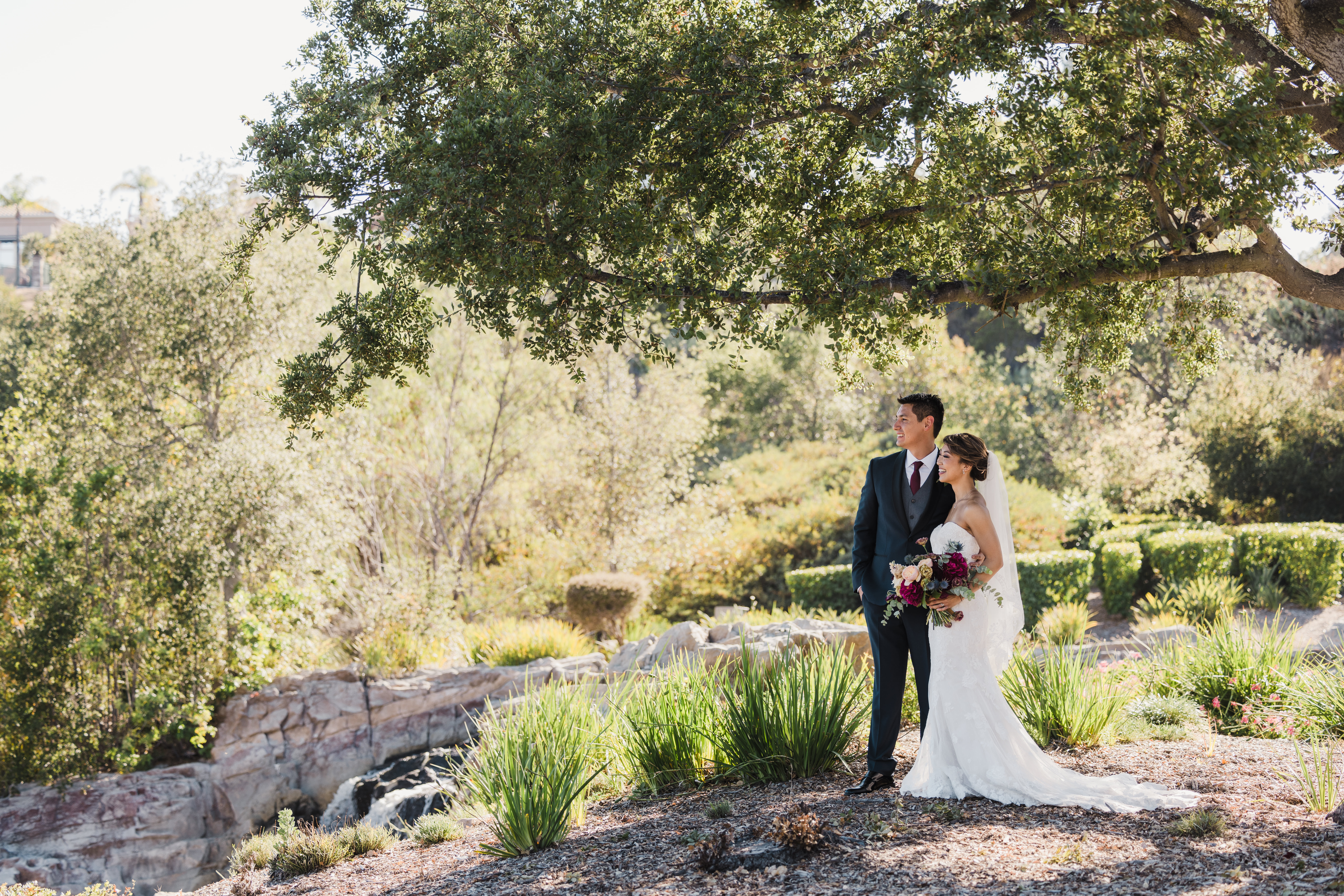 bride in strapless lace wedding dress and groom in navy tuxedo take outdoor portrait photos around Dove Canyon Golf Club
