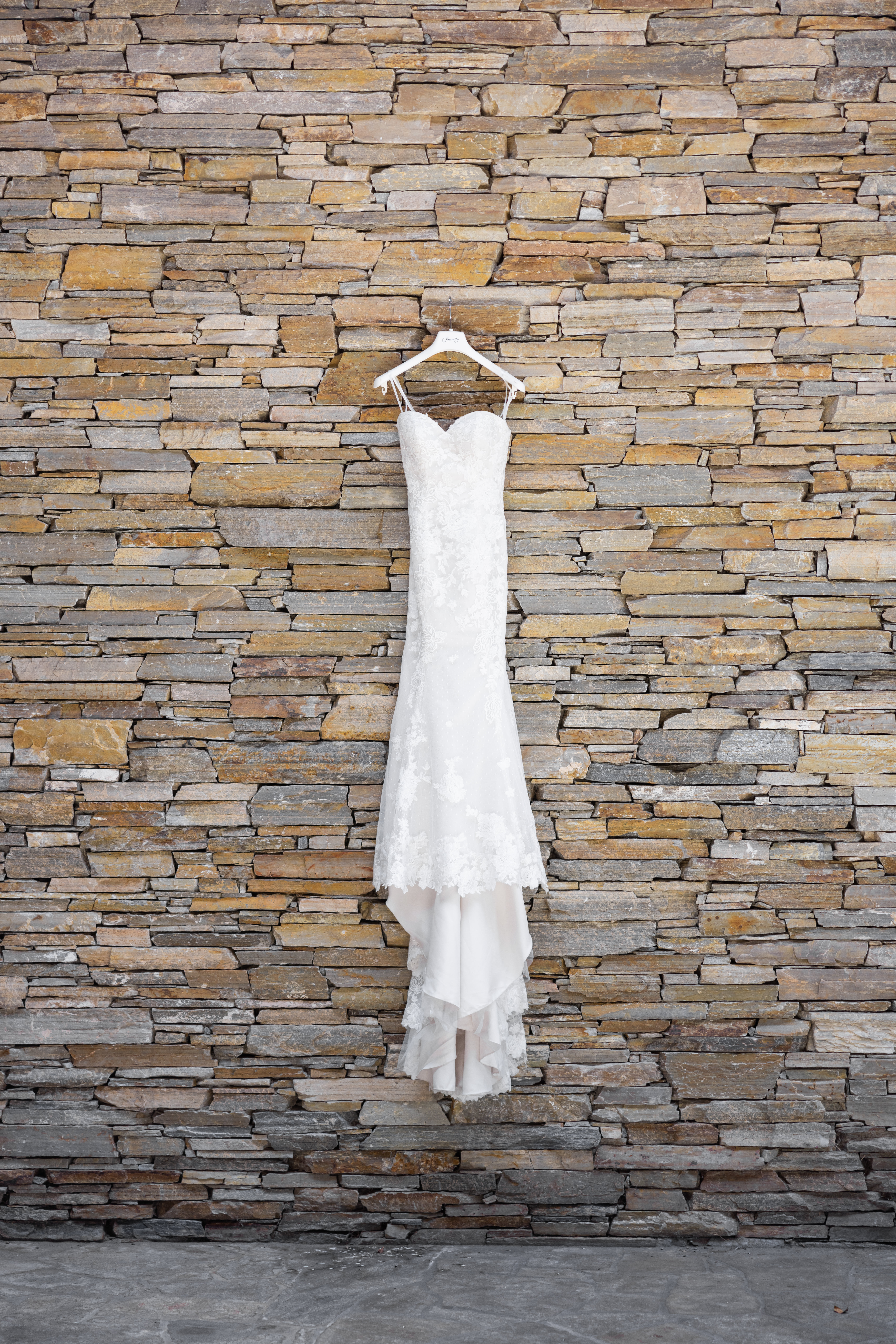 strapless lace wedding dress with train hanging from personalized hanger