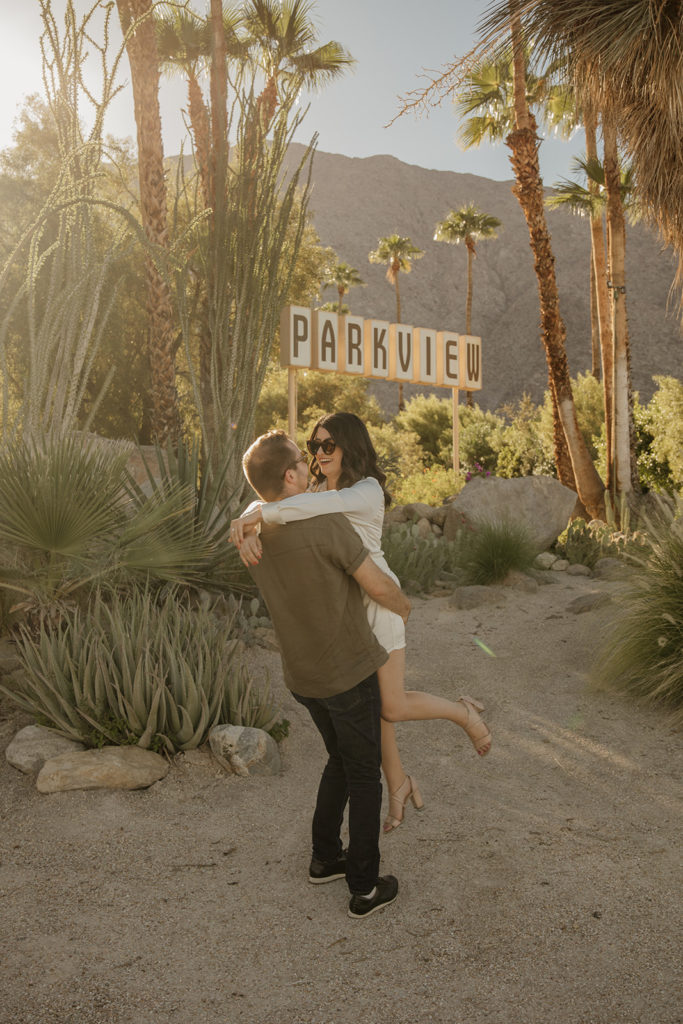 desert engagement photo session with bride in long sleeve silk mini dress and groom in short sleeve army green button up 