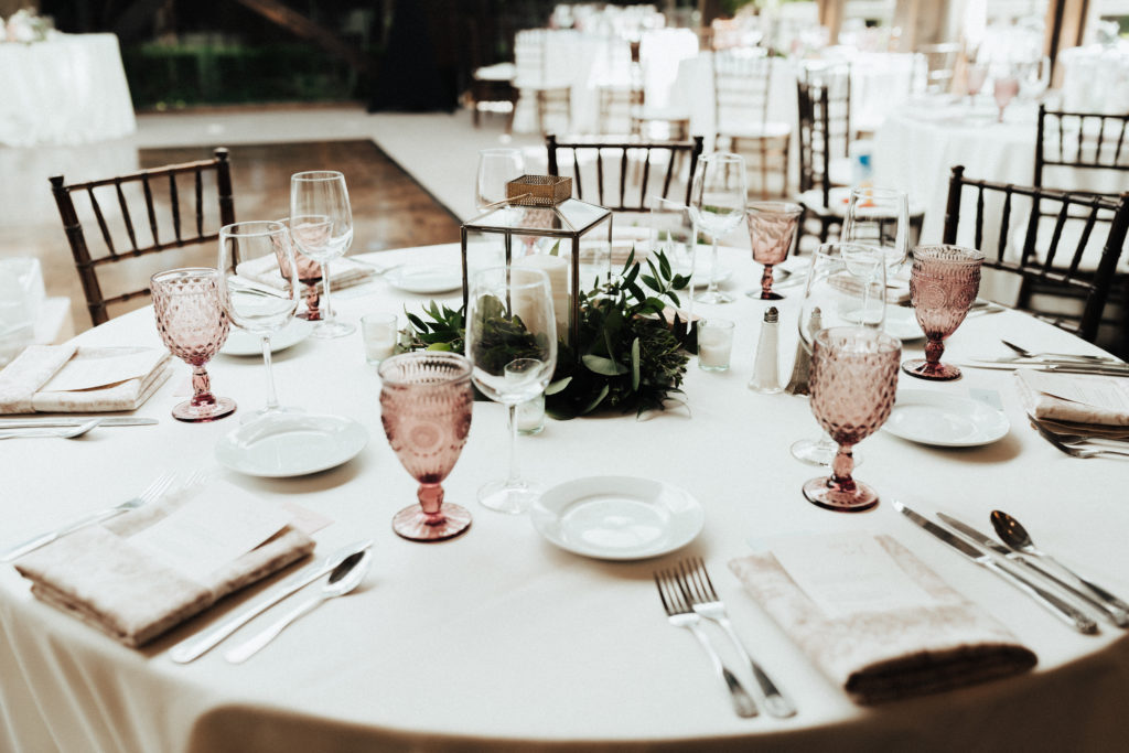 spring wedding reception at The Oak Room at Calamigos Ranch with pink goblets, wooden chairs and white linens