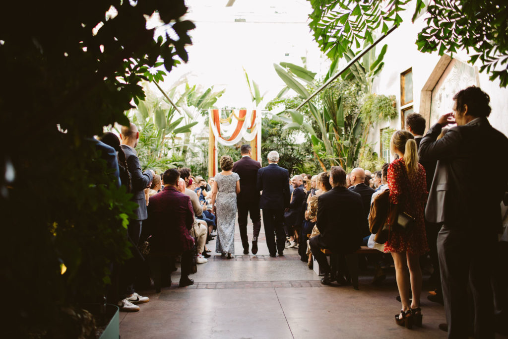 groom walking down aisle with parents during earth toned wedding ceremony at Valentine DTLA