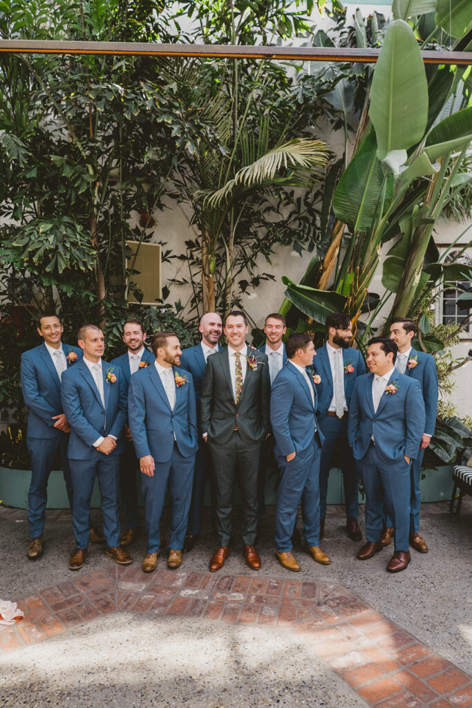 groom in bright floral tie with groomsmen in blue suits and white ties