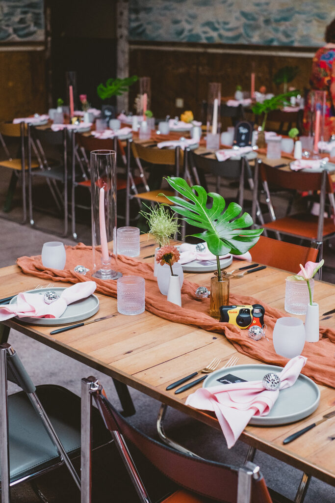 jungle disco themed wedding reception at Valentine DTLA with monstera leaves, disposable cameras, pink and orange linens and disco balls