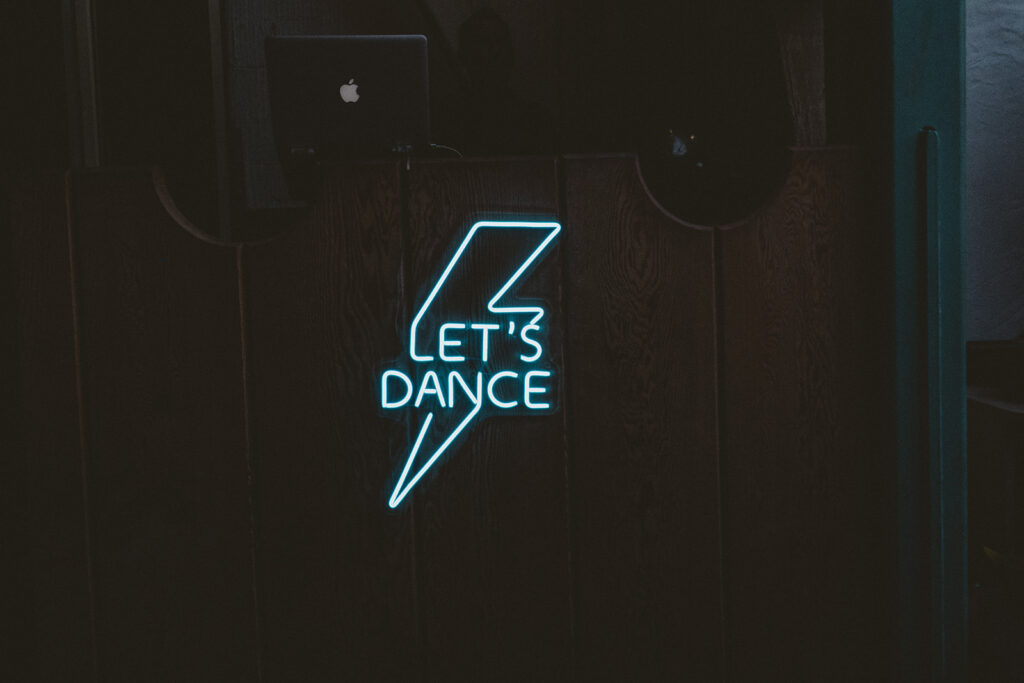 neon sign reading "let's dance"